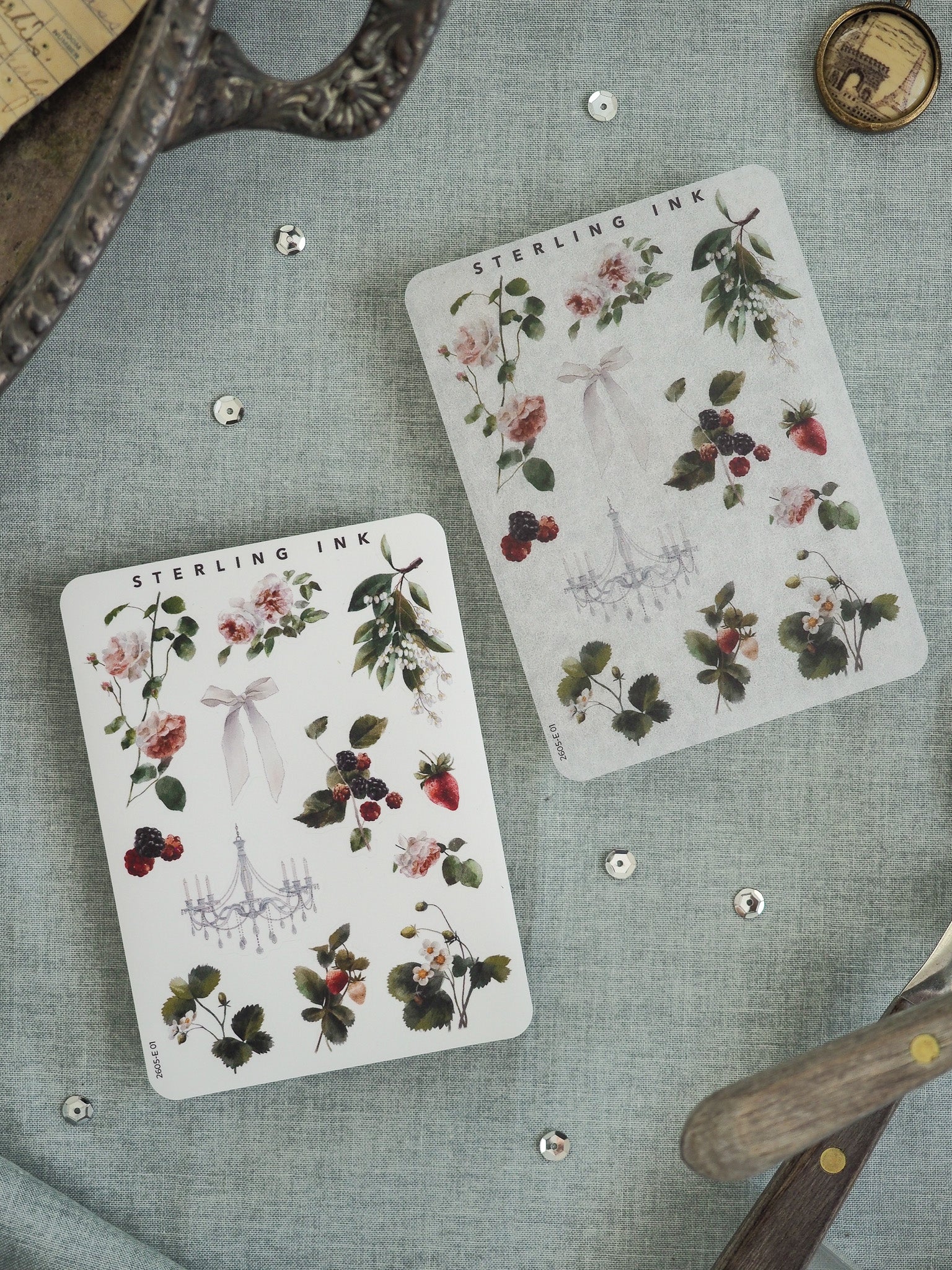 Vintage watercolor sticker sheet featuring a botanical cluster of ripe red berries, pink roses, green foliage, and a delicate chandelier illustration, printed on off-white paper.