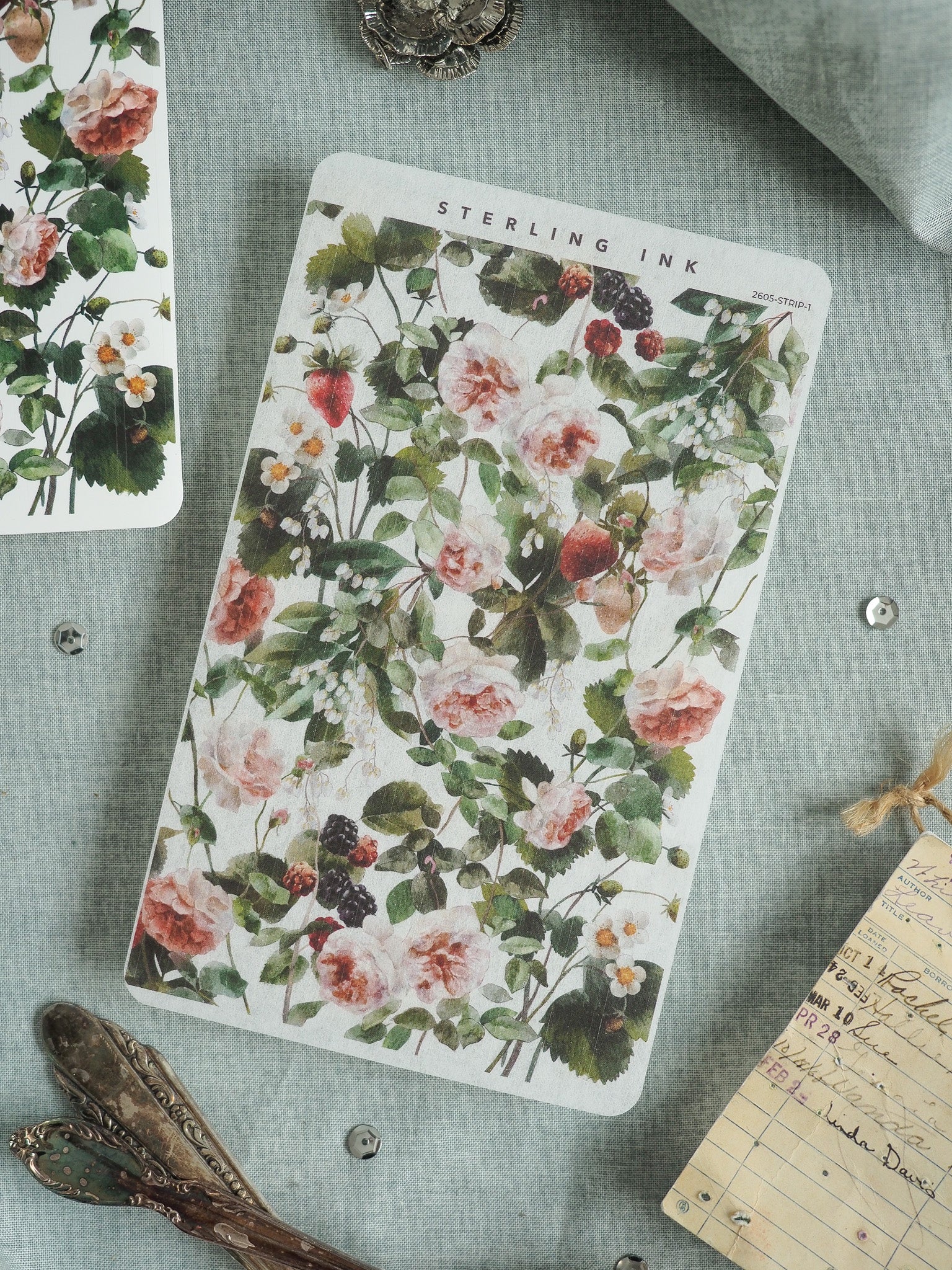 Vintage floral sticker featuring a lush, dense pattern of soft pink roses, white blossoms, and deep berries set against vibrant green foliage.