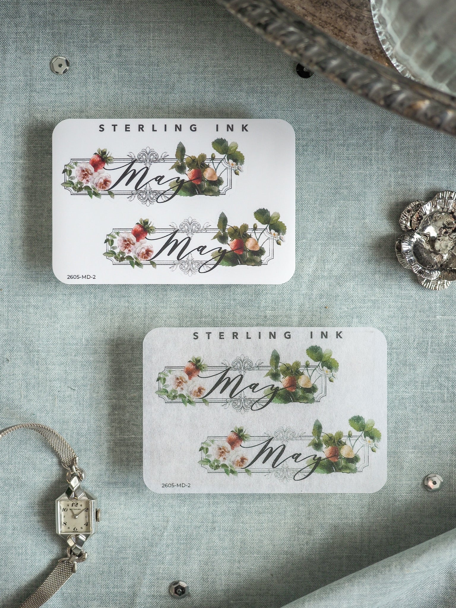 Decorative "May" stickers by Sterling Ink featuring delicate spring floral wreaths, incorporating soft pink roses and sage greenery.