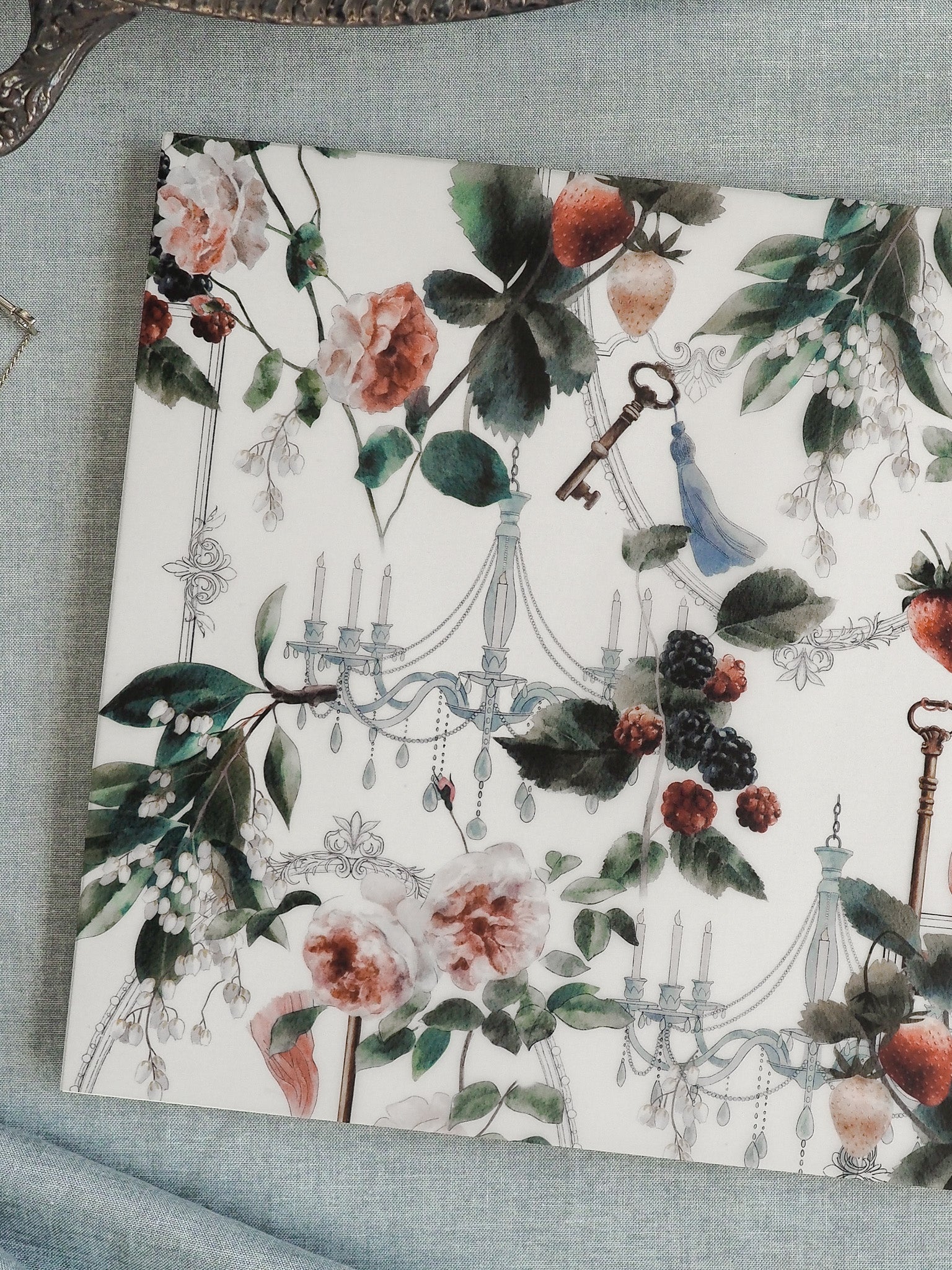 Elegant watercolor pattern illustration featuring blush roses, deep green foliage, scattered dark berries, and vintage elements like candelabras, keys, and a blue bird.