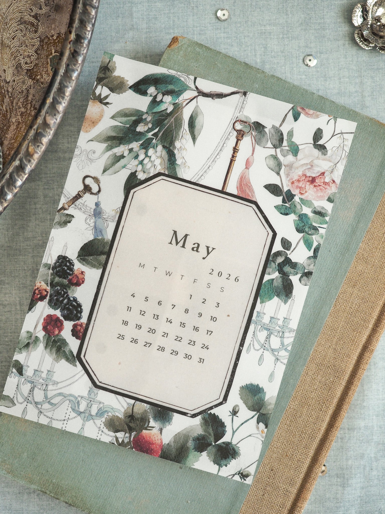 Decorative June 2026 calendar featuring a vintage botanical motif, surrounded by lush illustrations of roses, rich greenery, and delicate floral accents.