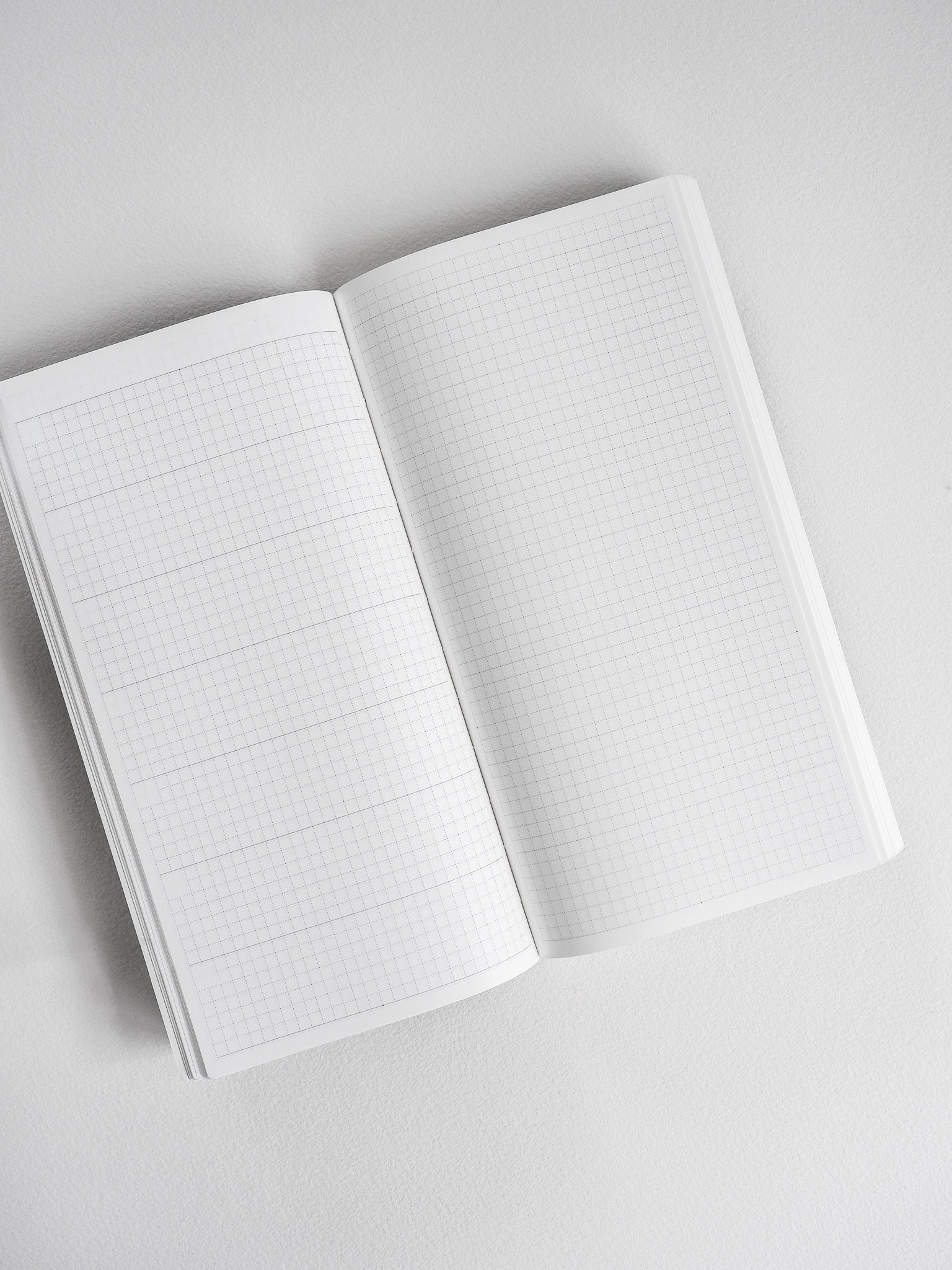 Open planner displaying crisp, comprehensive light-toned graph paper with precise grid lines for meticulous planning and writing.