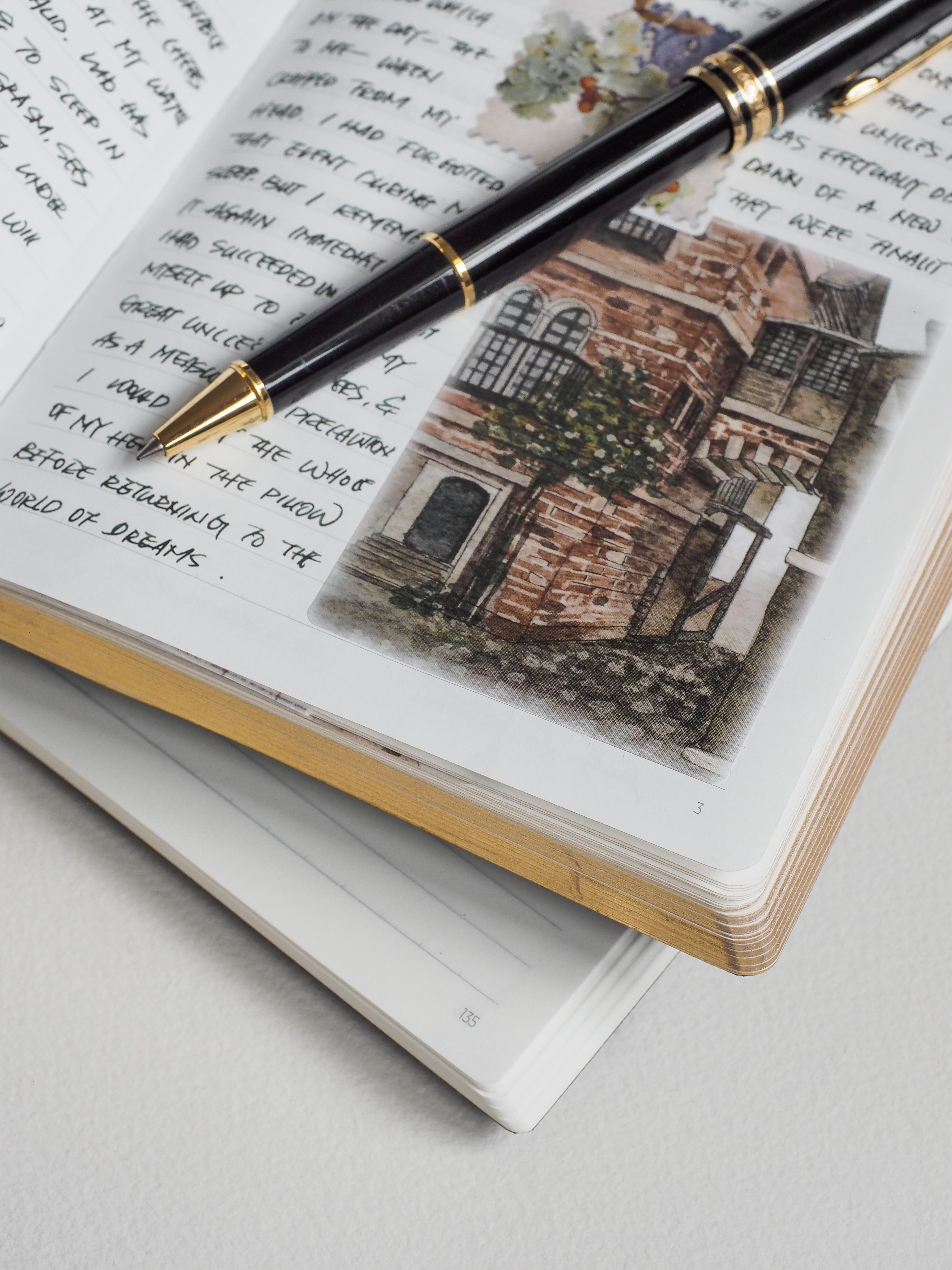 Open A5 lined notebook displaying a detailed, sepia-toned sketch of a historic structure alongside ruled, creamy pages.