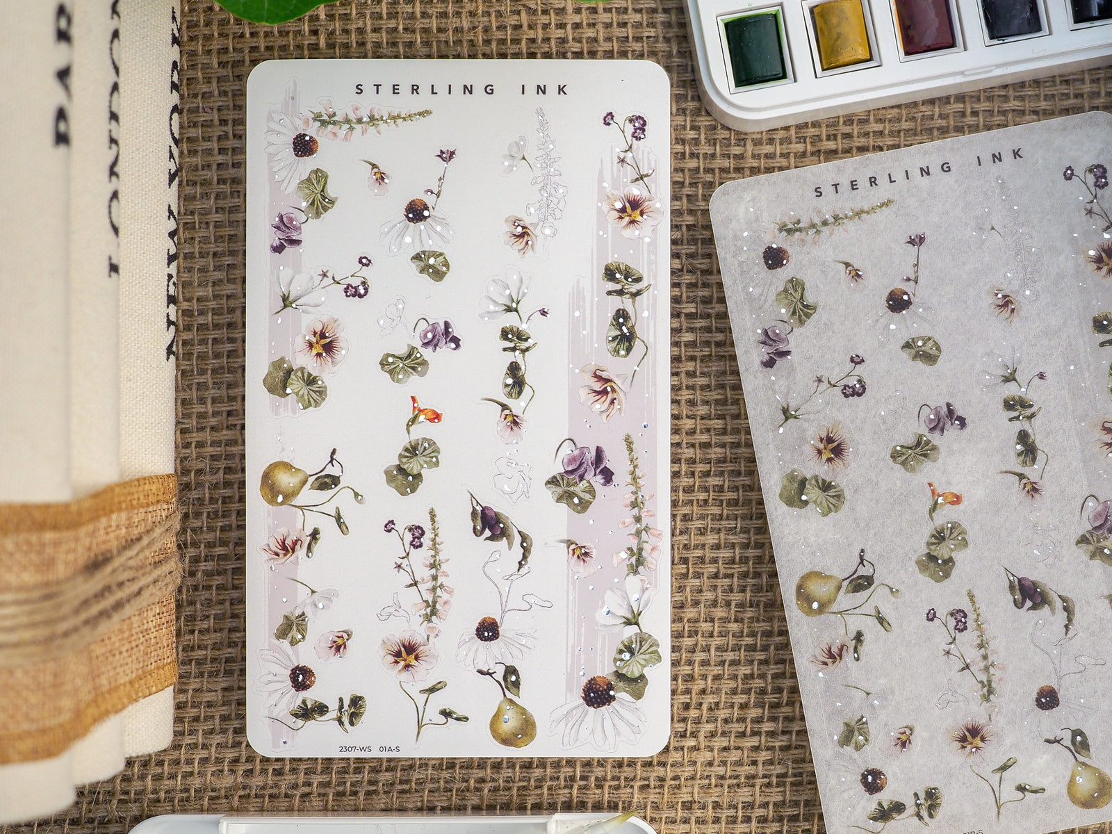 Elegant botanical sticker sheet featuring a dense, delicate pattern of muted wildflowers, leaves, and whimsical garden elements.