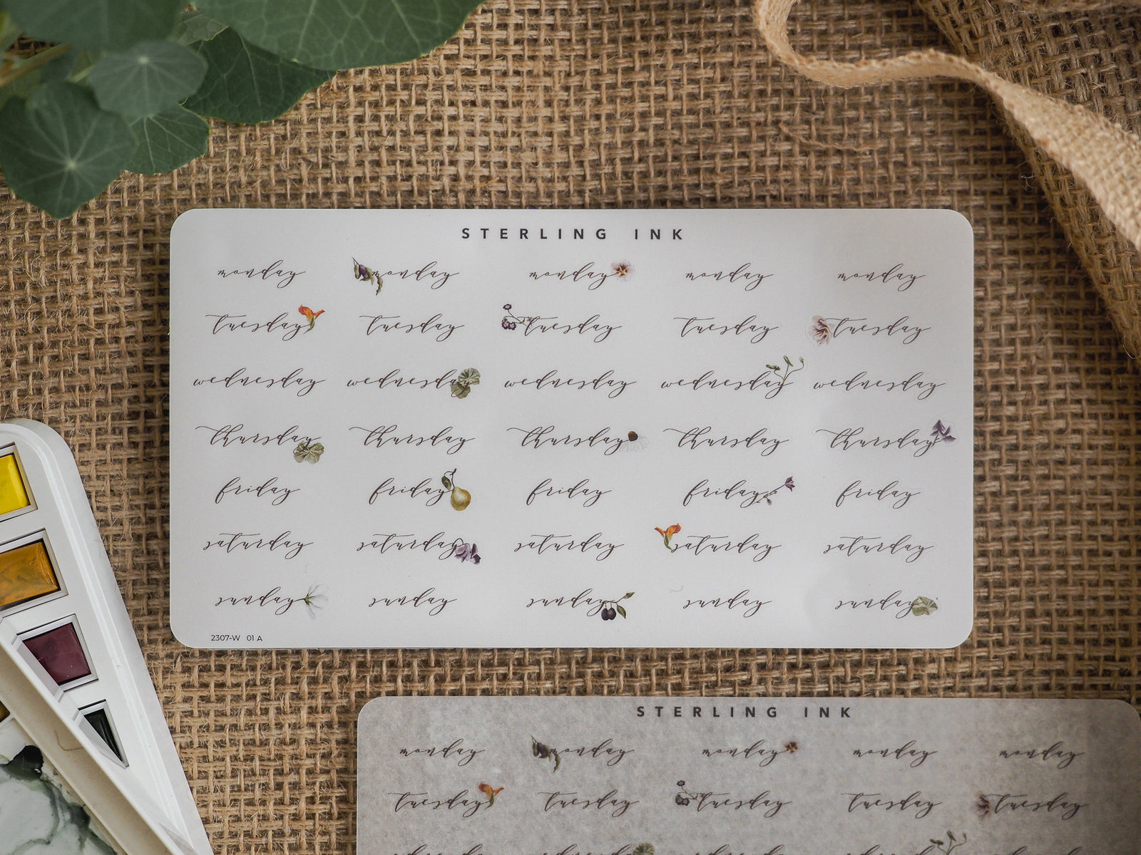 Detailed sheet of vintage-style weekday stickers from Sterling Ink, featuring decorative dates and days of the week like "Monday" and "Tuesday" for planning.
