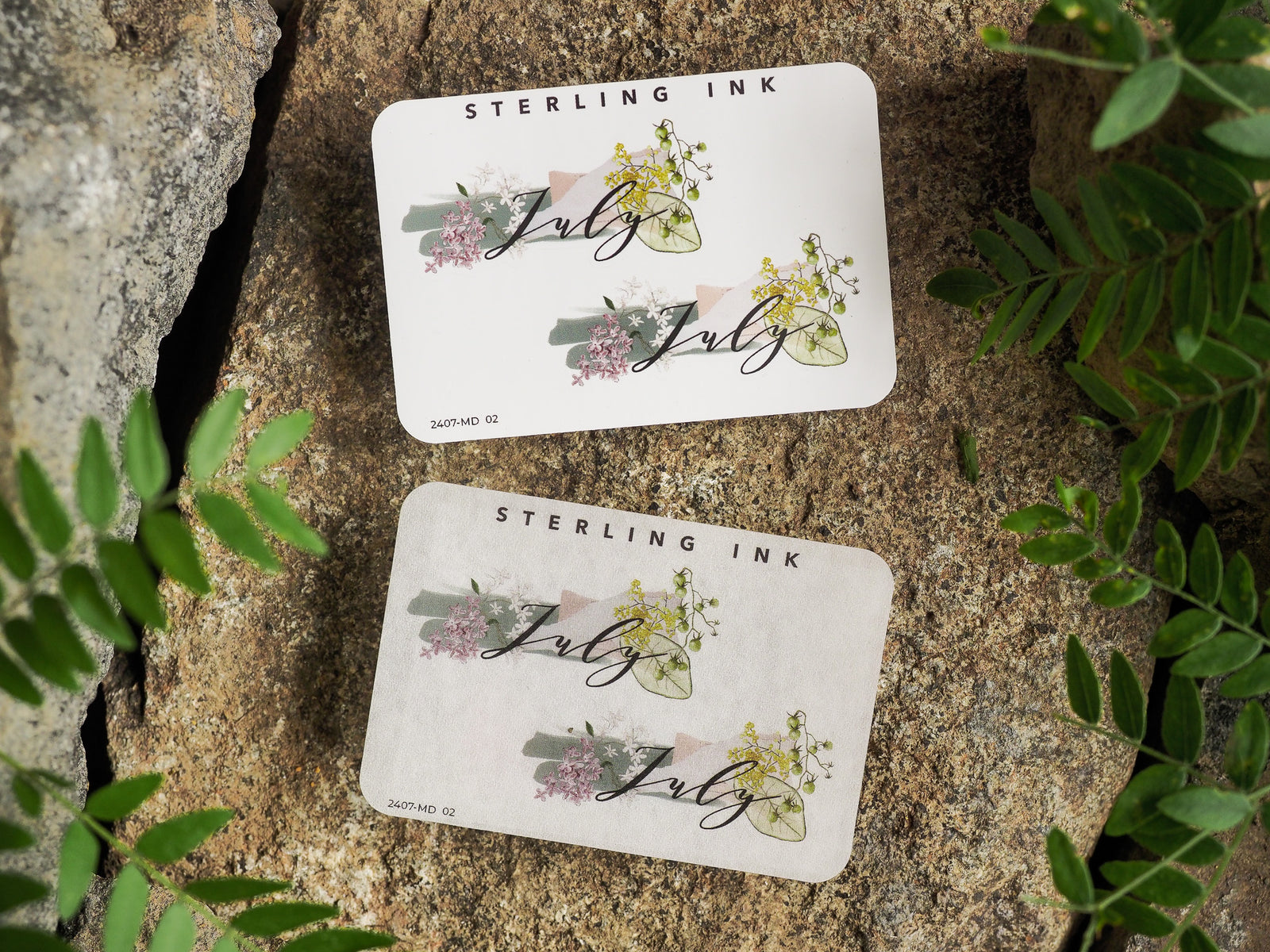 Floral month stickers for July featuring a delicate design with the scripted name surrounded by soft pink and sage green botanical accents.