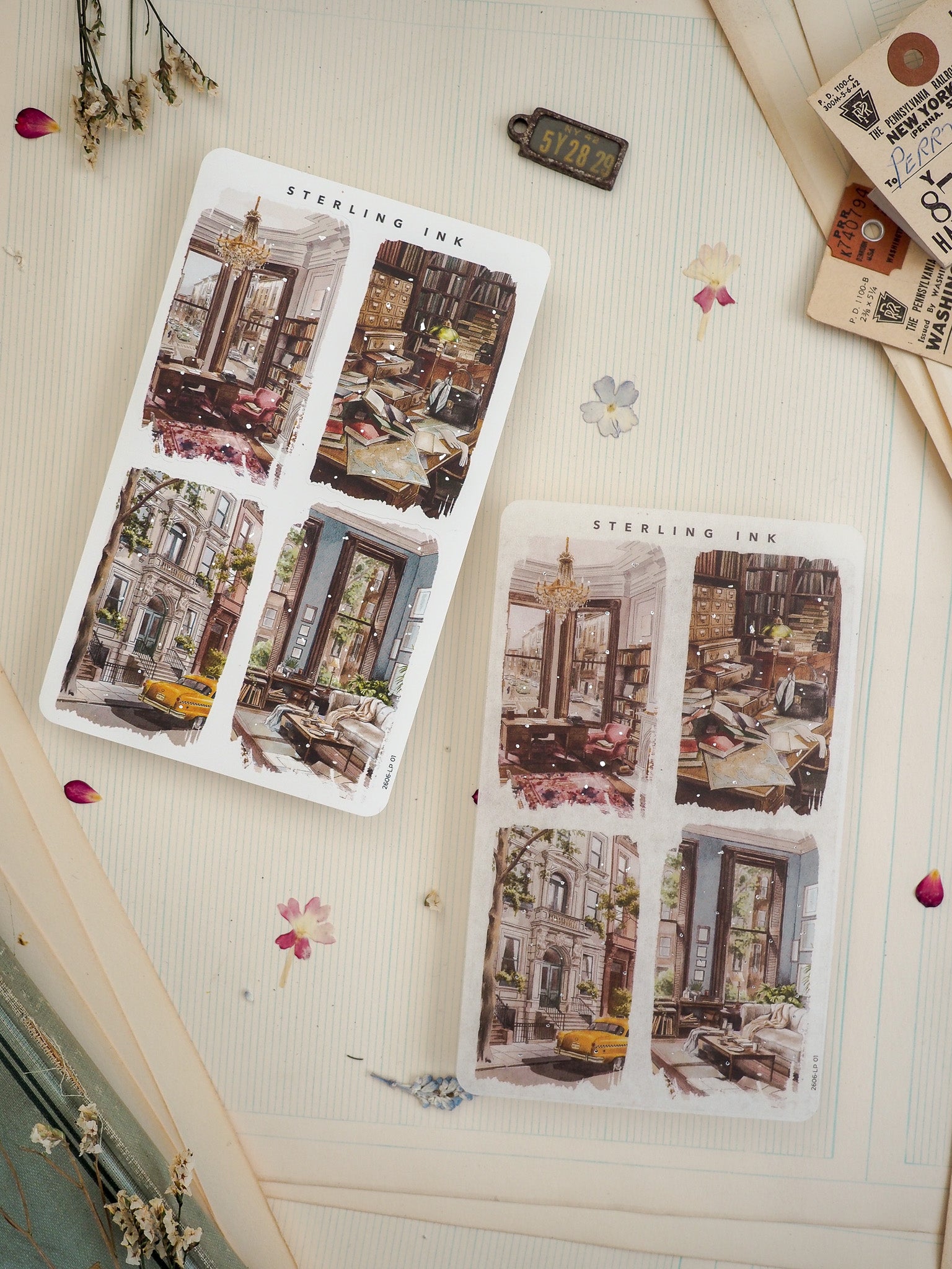 Two "STERLING INK" sticker sheets featuring four-panel illustrated grids of nostalgic European scenes, showcasing bustling cafe interiors and charming old city streets.