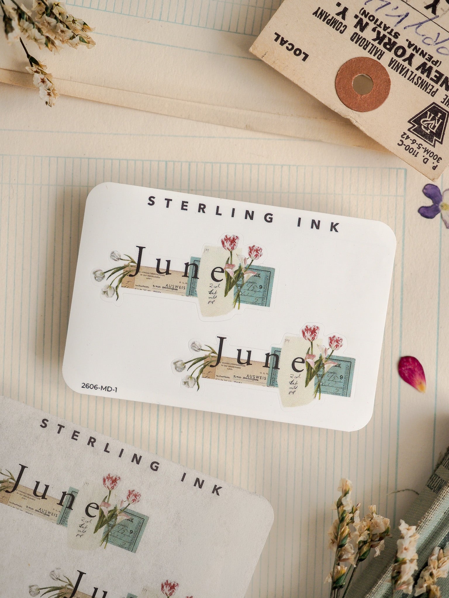 White card featuring "STERLING INK" and a romantic, vintage design with watercolor floral illustrations and rustic "June" postcard labels.