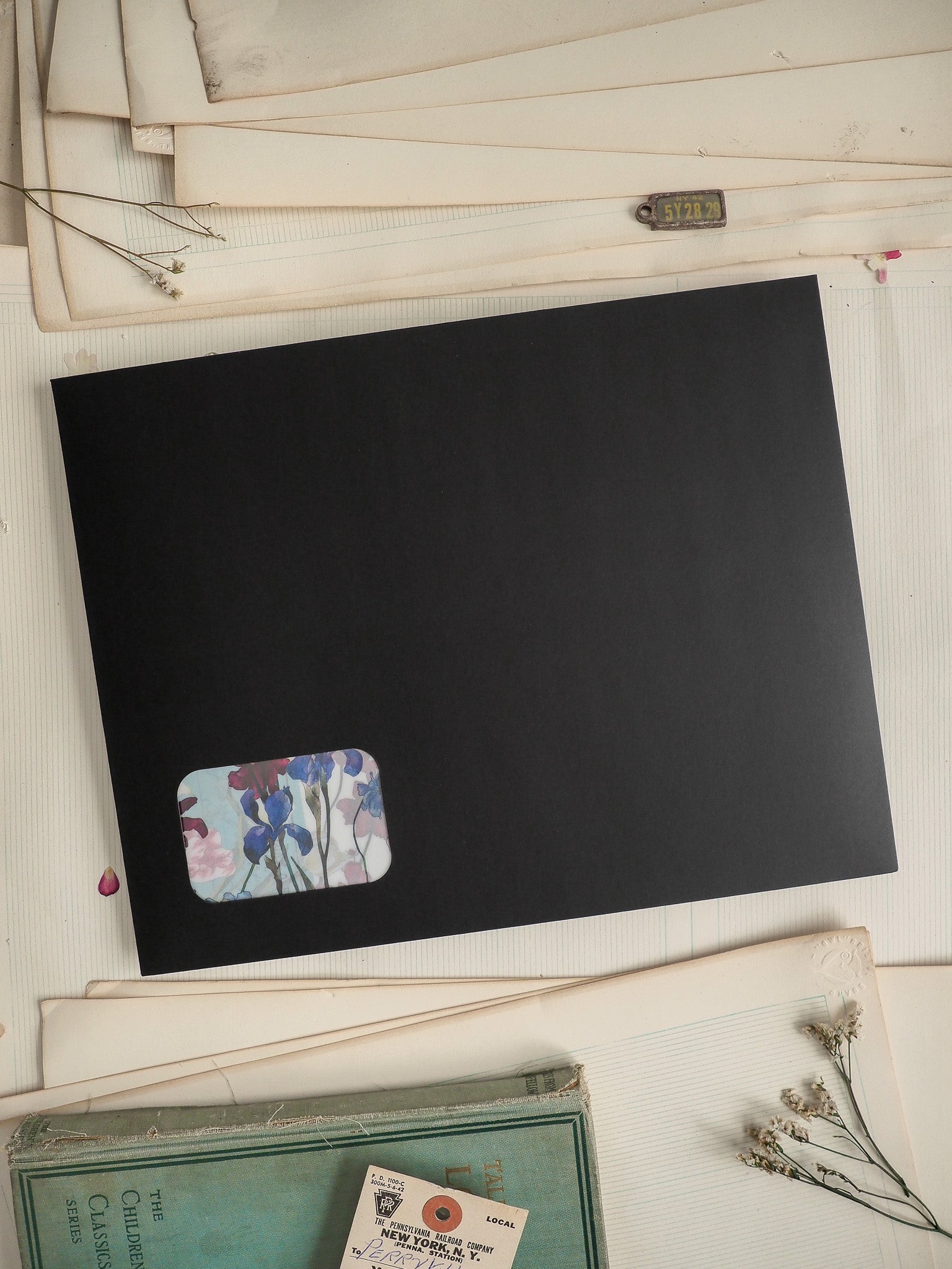 Black card featuring a watercolor floral sticker design with soft blue, lavender, and blush pink tones.