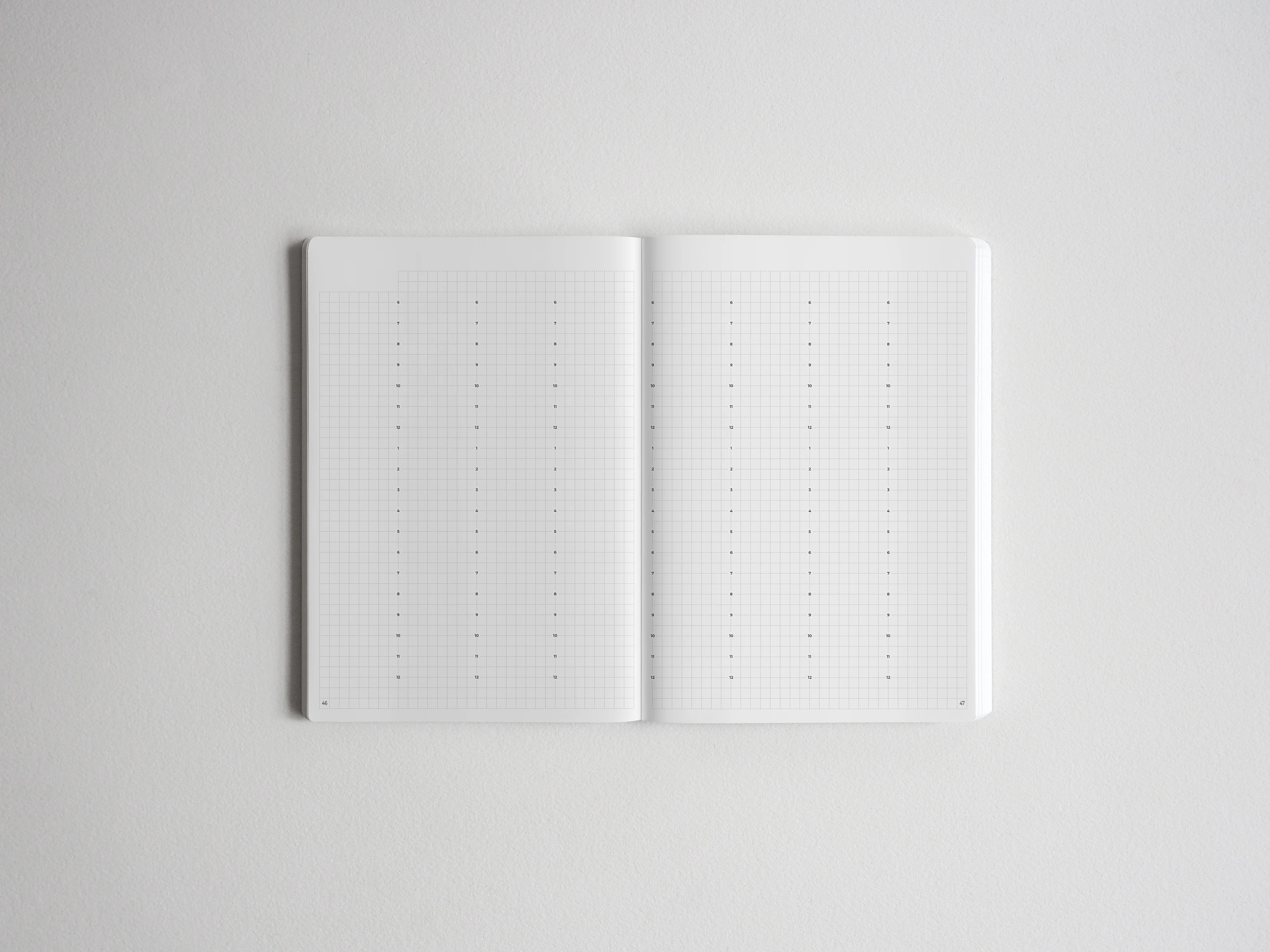 Open notebook displaying two pages of precise dotted grid paper, ideal for bullet journaling, planning, and creative note-taking.