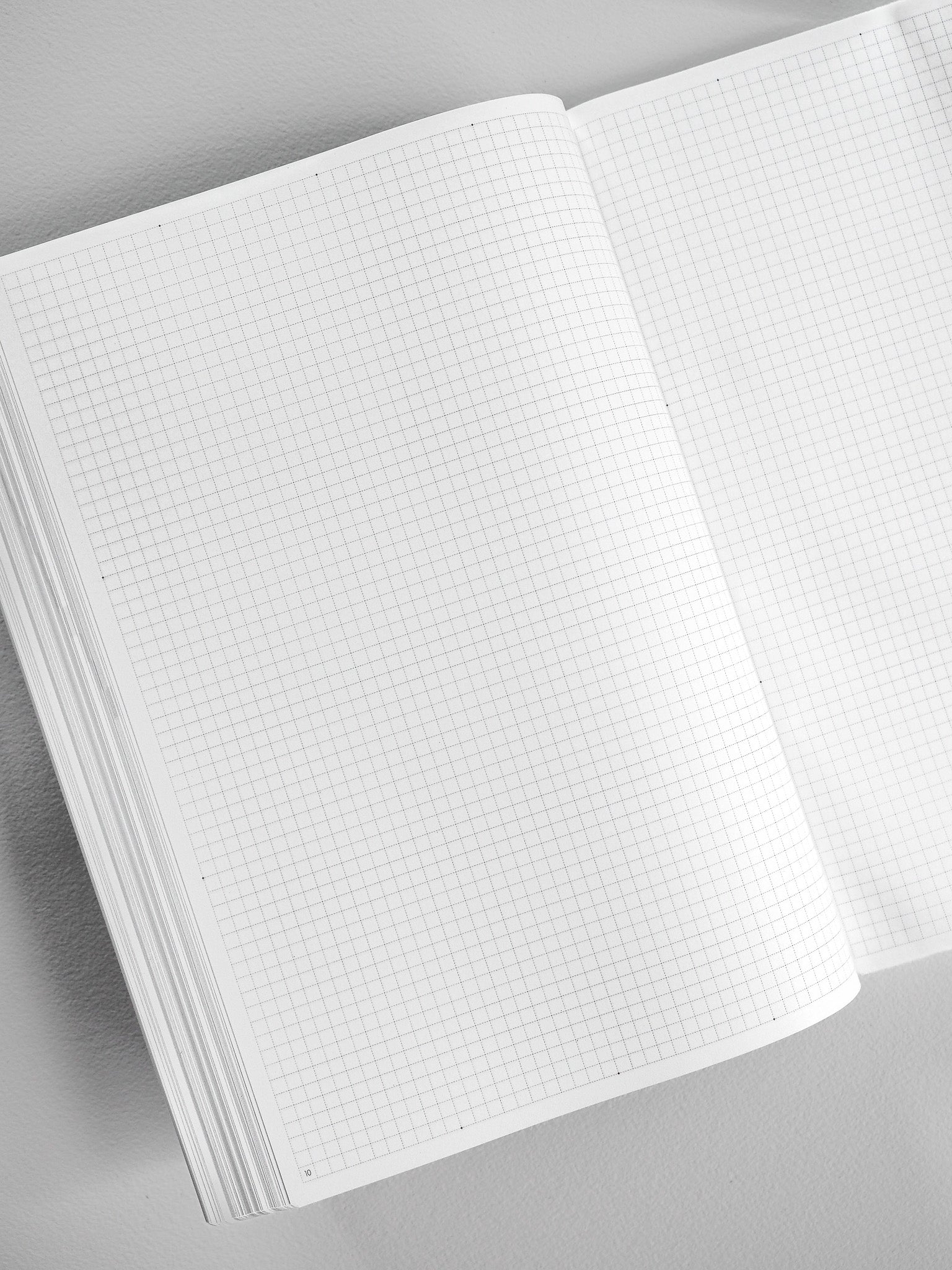 An open B5 booklet reveals uniform graph grid paper across its pages, designed for structured note-taking, planning, or journaling.