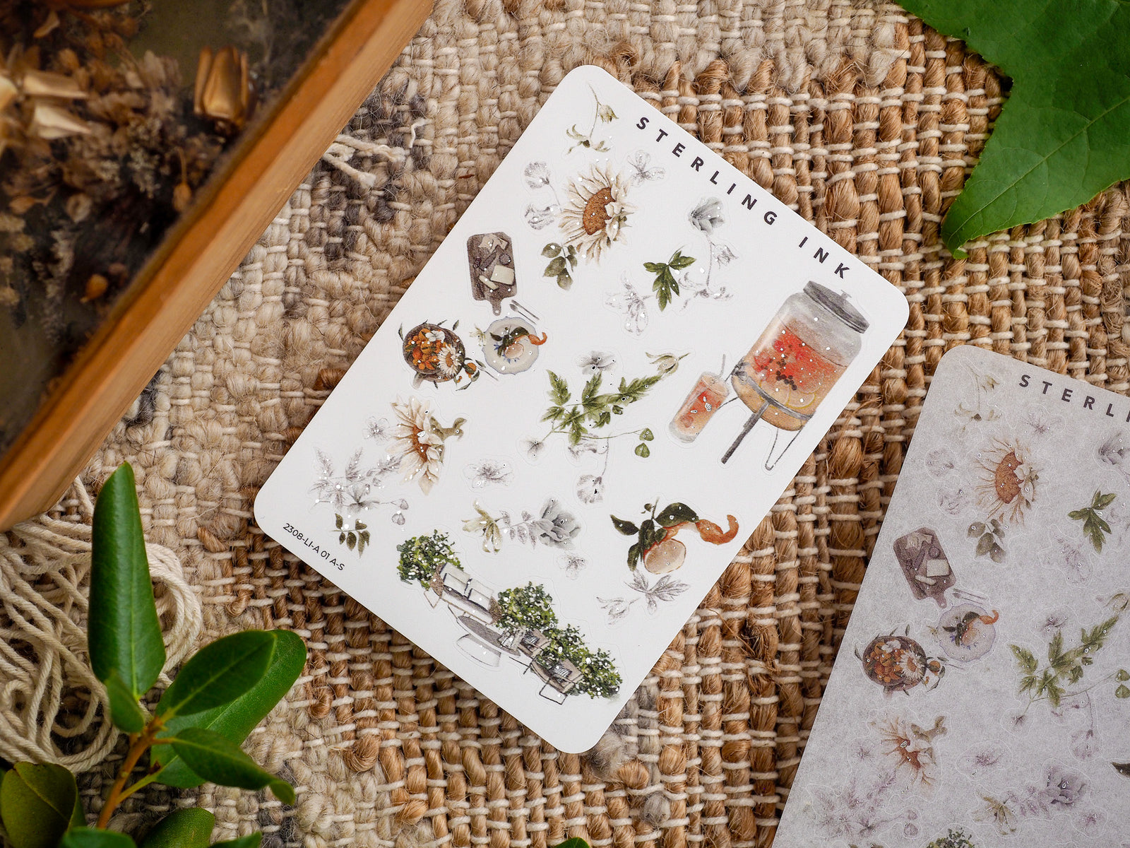 Botanical icon sticker sheet featuring delicate silver foil accents and detailed illustrations of various insects, wildflowers, and rustic natural elements.