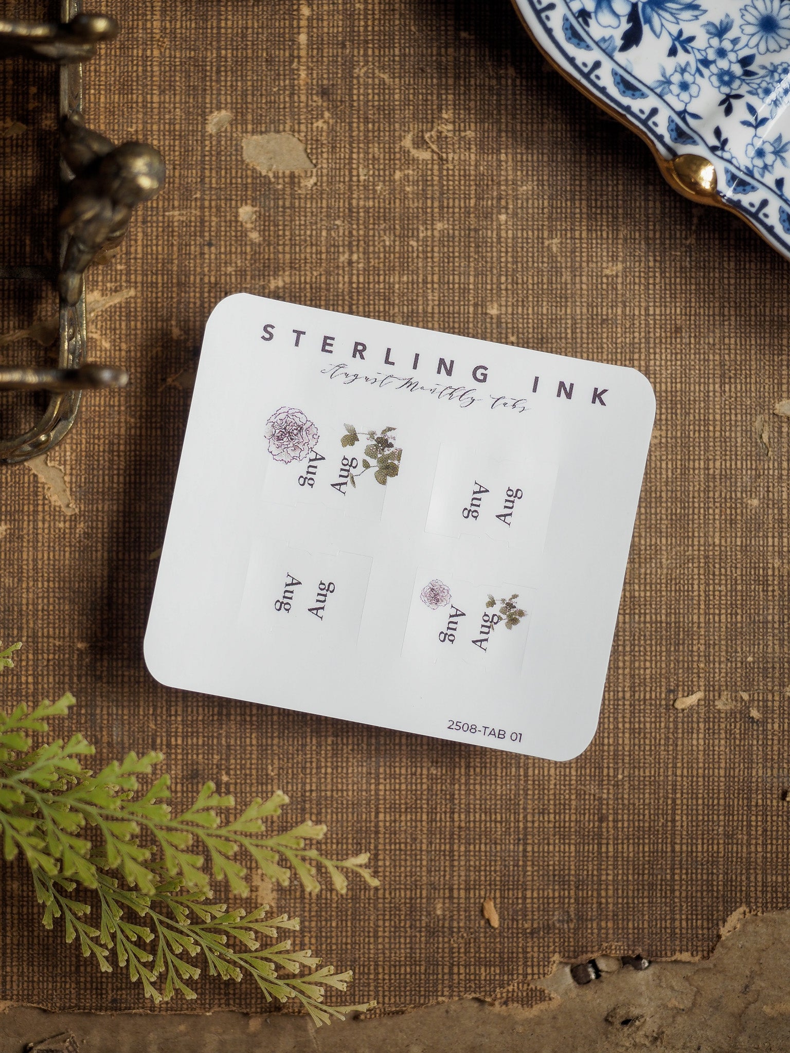 White "Sterling Ink" monthly planner tabs for August 2025, featuring delicate floral motifs and clean text design for organizing your schedule.