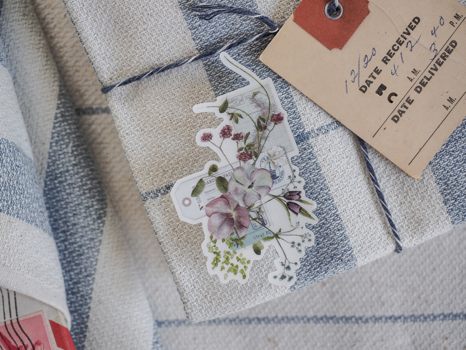 Clear vinyl die-cut sticker featuring a romantic bouquet of pastel-toned flowers, detailed greenery, and vintage botanical accents, perfect for August journaling.