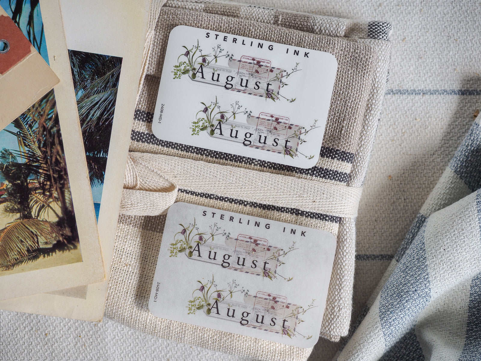 Cream-colored August month sticker set by Sterling Ink, decorated with delicate green watercolor flora surrounding the title for elegant journaling and planning.