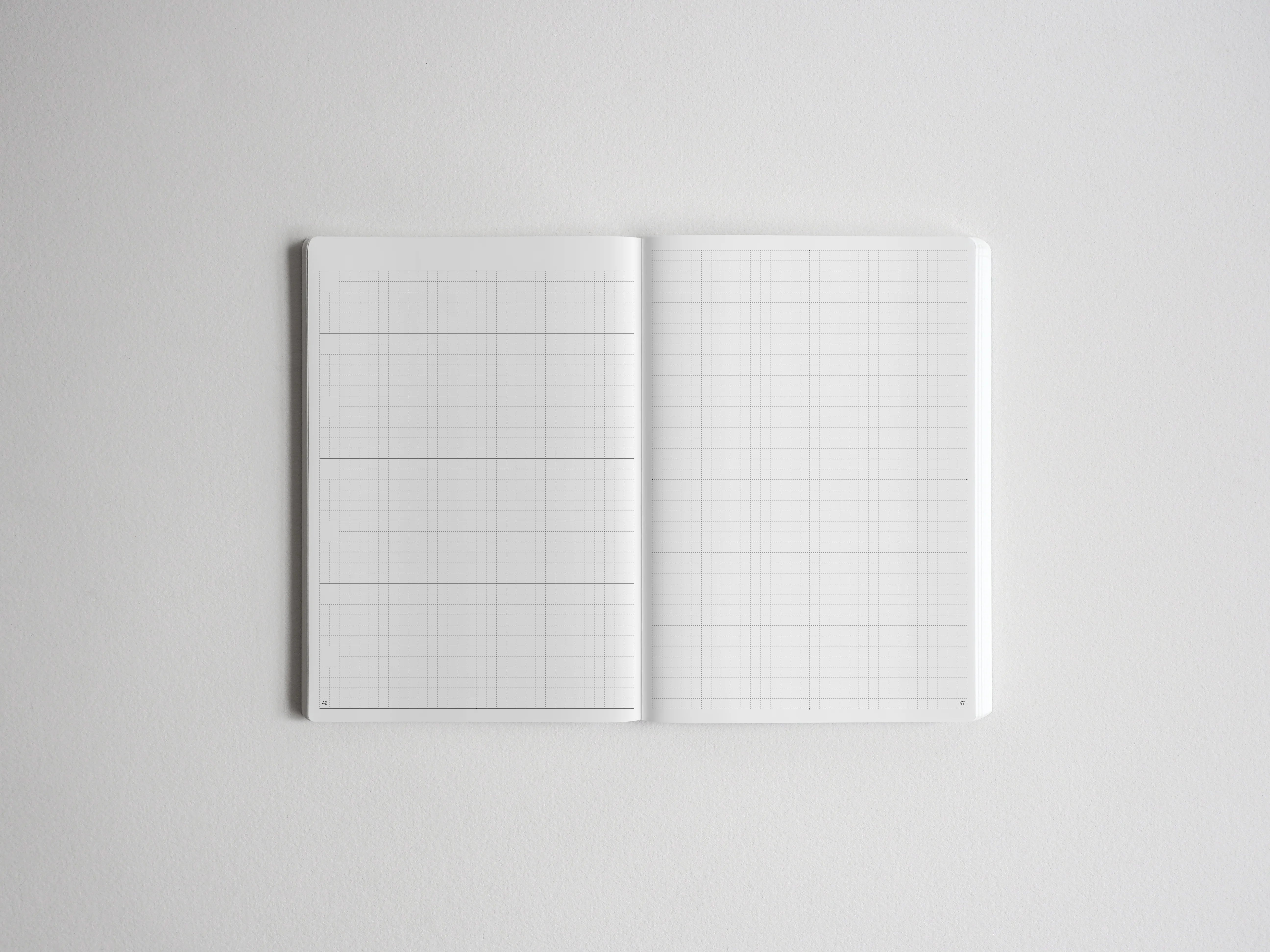 Open notebook displaying two pristine pages covered in a precise, light-colored graph paper grid, ideal for sketching, drafting, or structured note-taking.