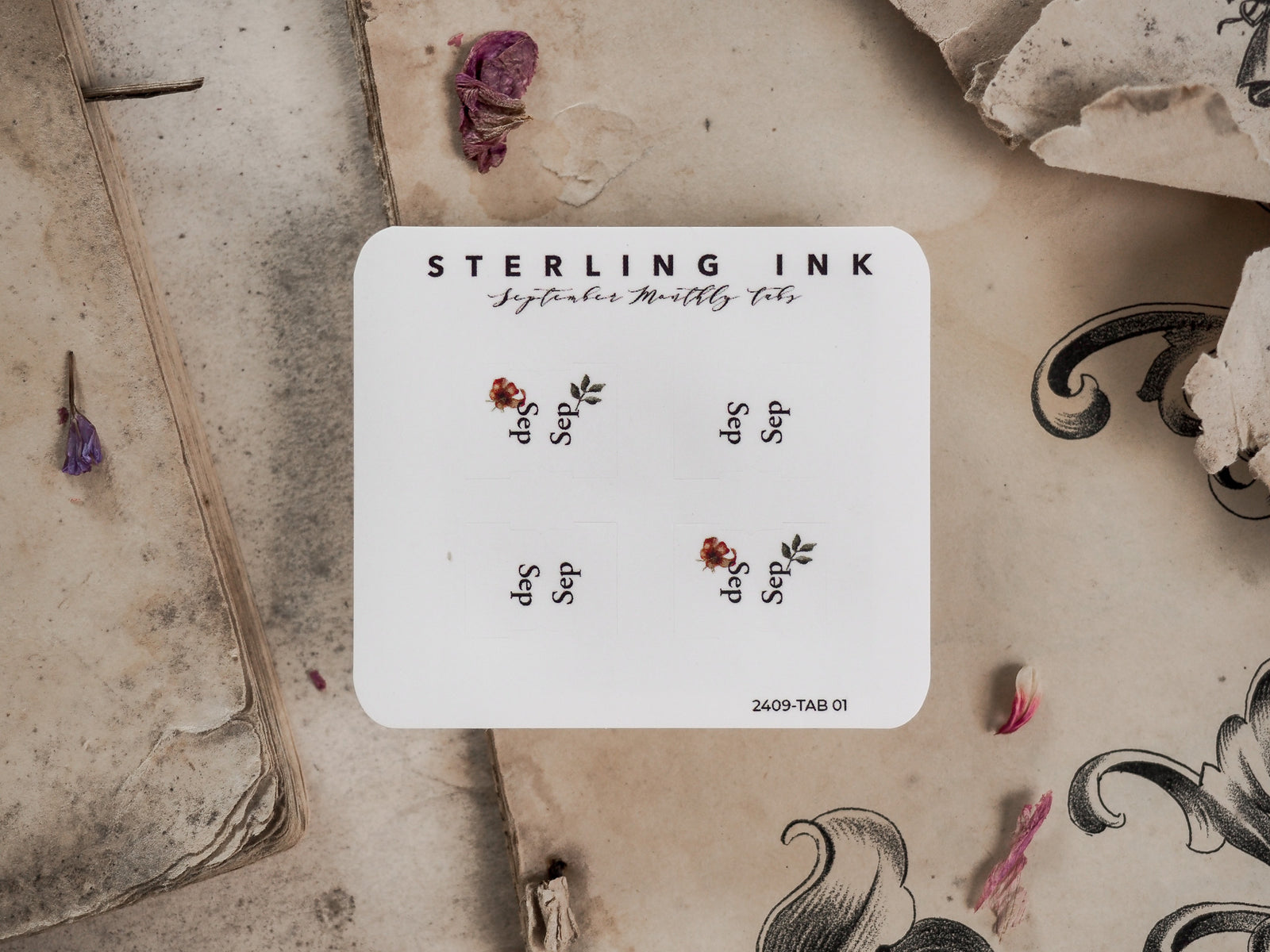 Minimalist white planner tab featuring delicate botanical accents and small clusters of sepals and leaves for September organization.