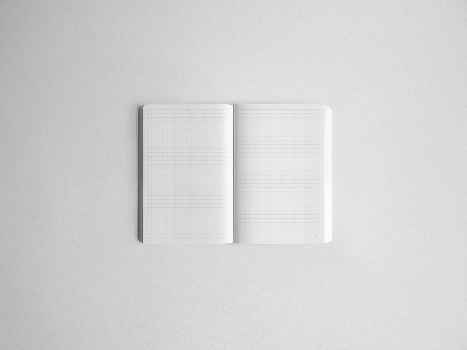 Open notebook displaying white graph paper grids on both pages, ideal for planning, drawing, or journaling.