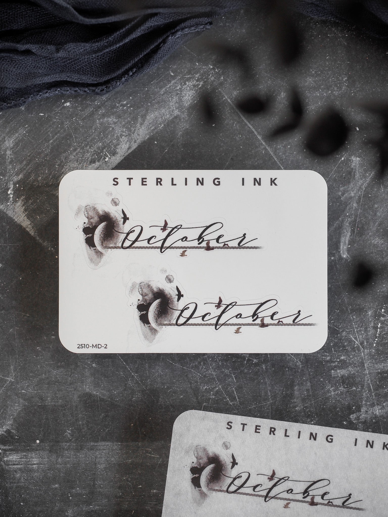 A sophisticated, monochrome sticker label featuring hand-lettered "October" and "Sterling Ink" in an elegant, journaling-style script perfect for planners.