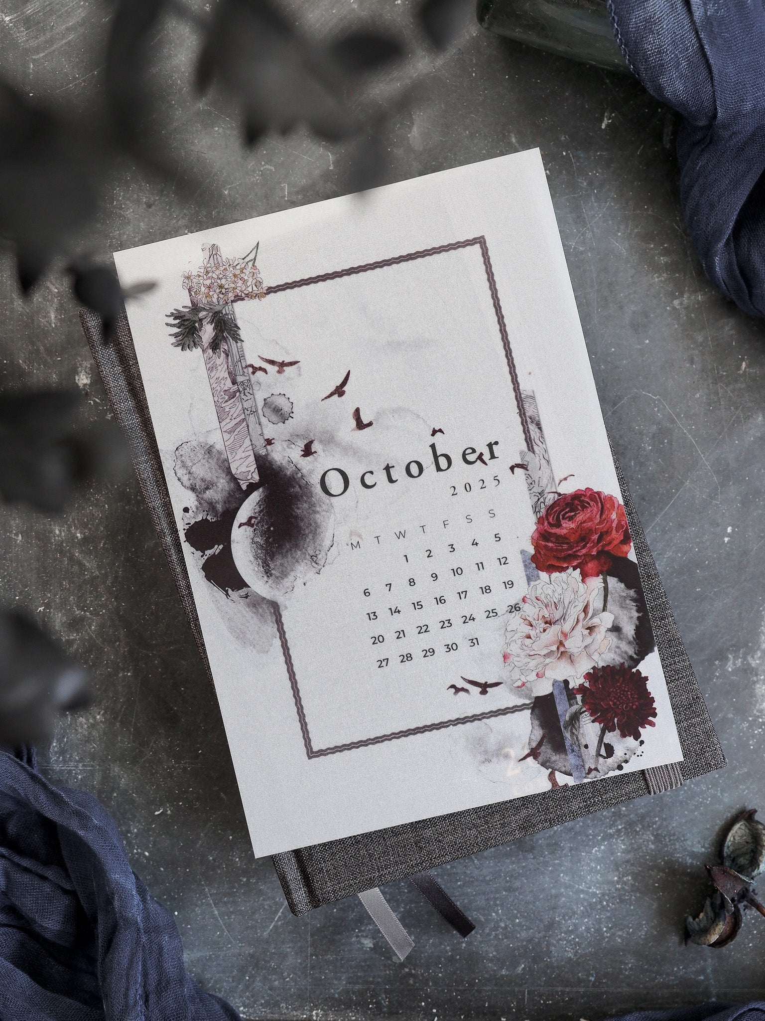 Elegant October 2025 monthly calendar featuring an autumnal theme with deep red roses, scattered fall foliage, and a rustic, hand-drawn aesthetic on cream paper.