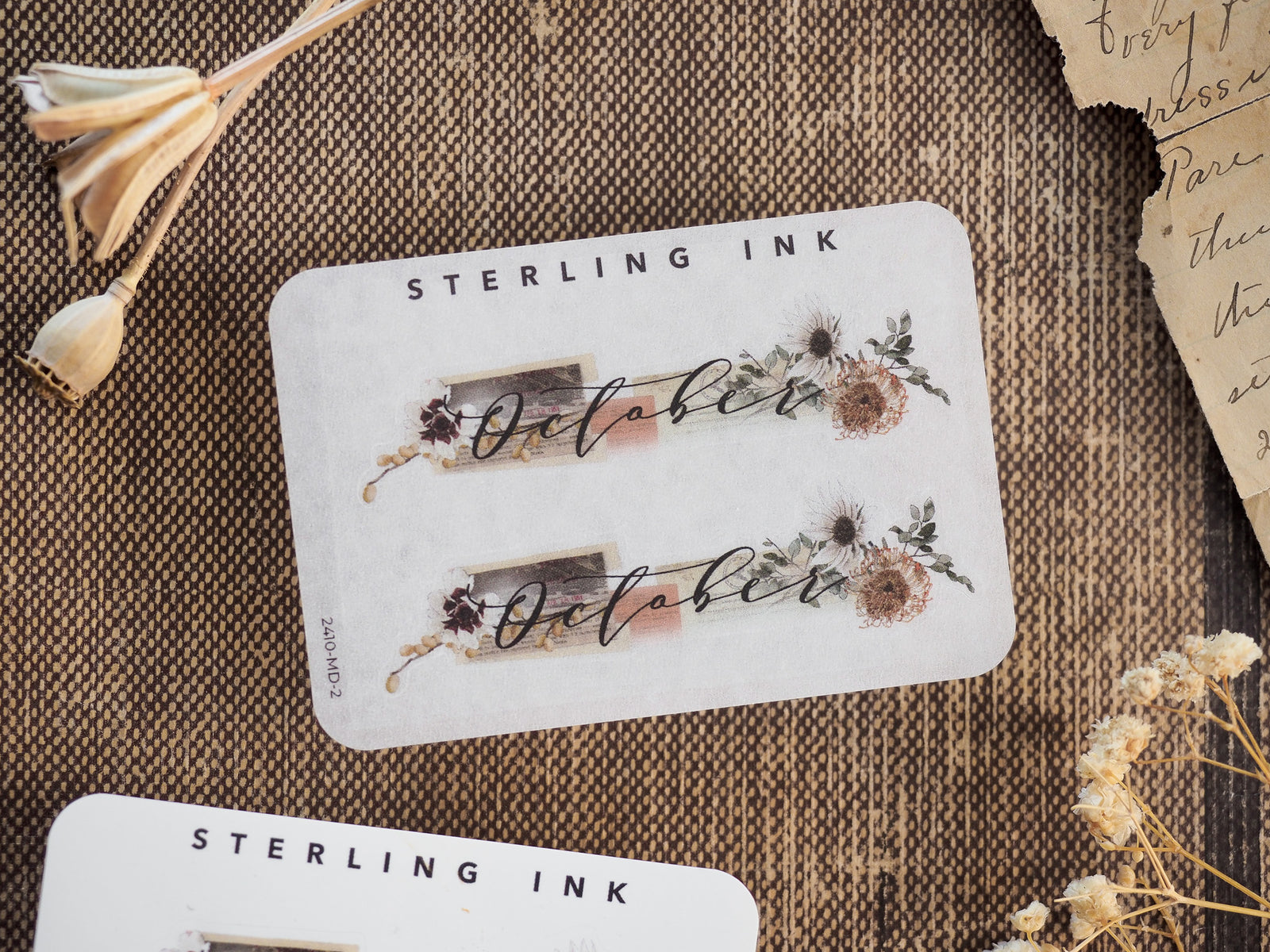 Rustic October month sticker featuring delicate botanical wreaths and berries framing the script text, perfect for autumnal journaling and planning.