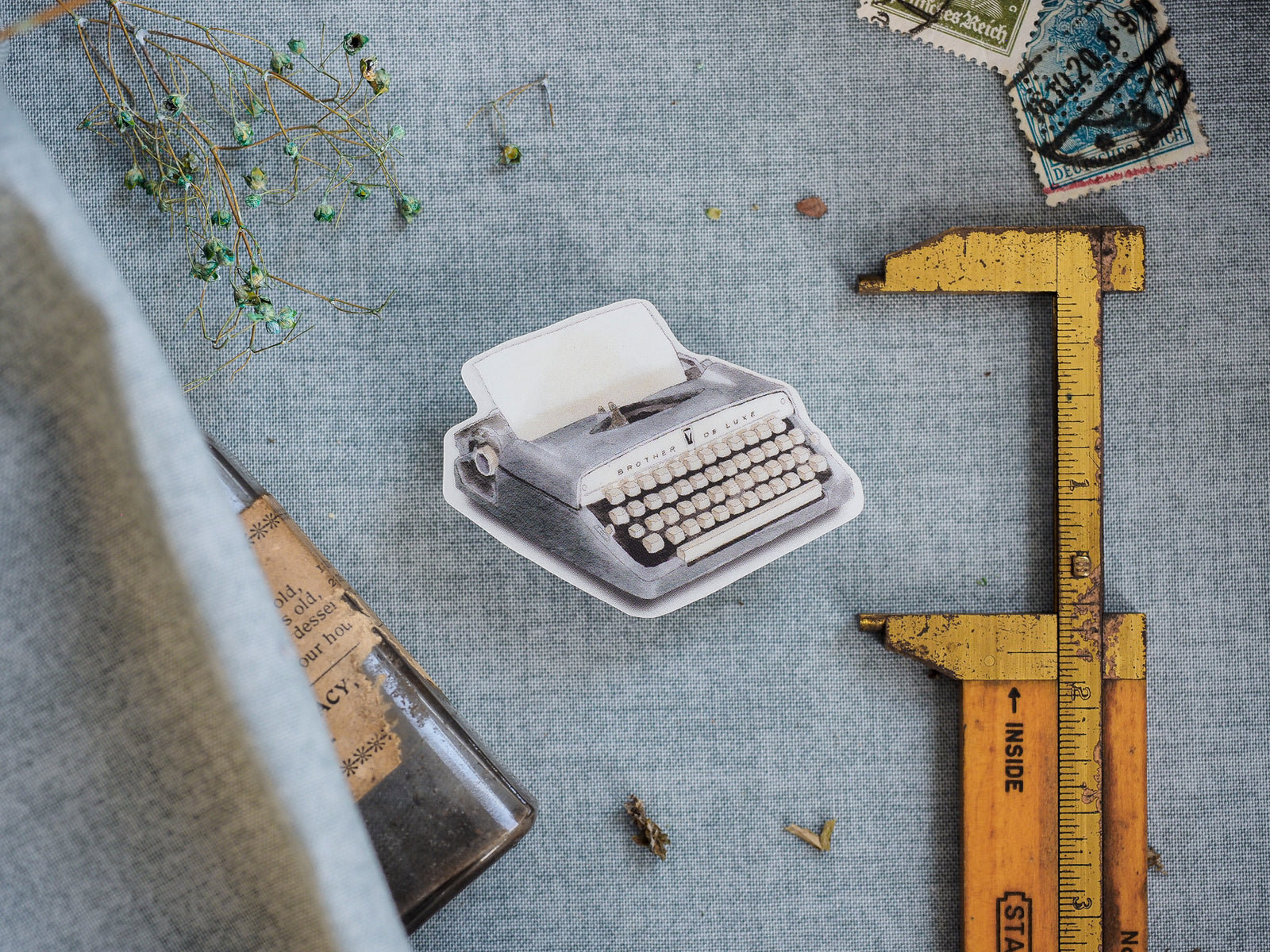Vintage die-cut sticker showing a detailed, nostalgic view of a classic typewriter, perfect for retro journaling and scrapbooking.