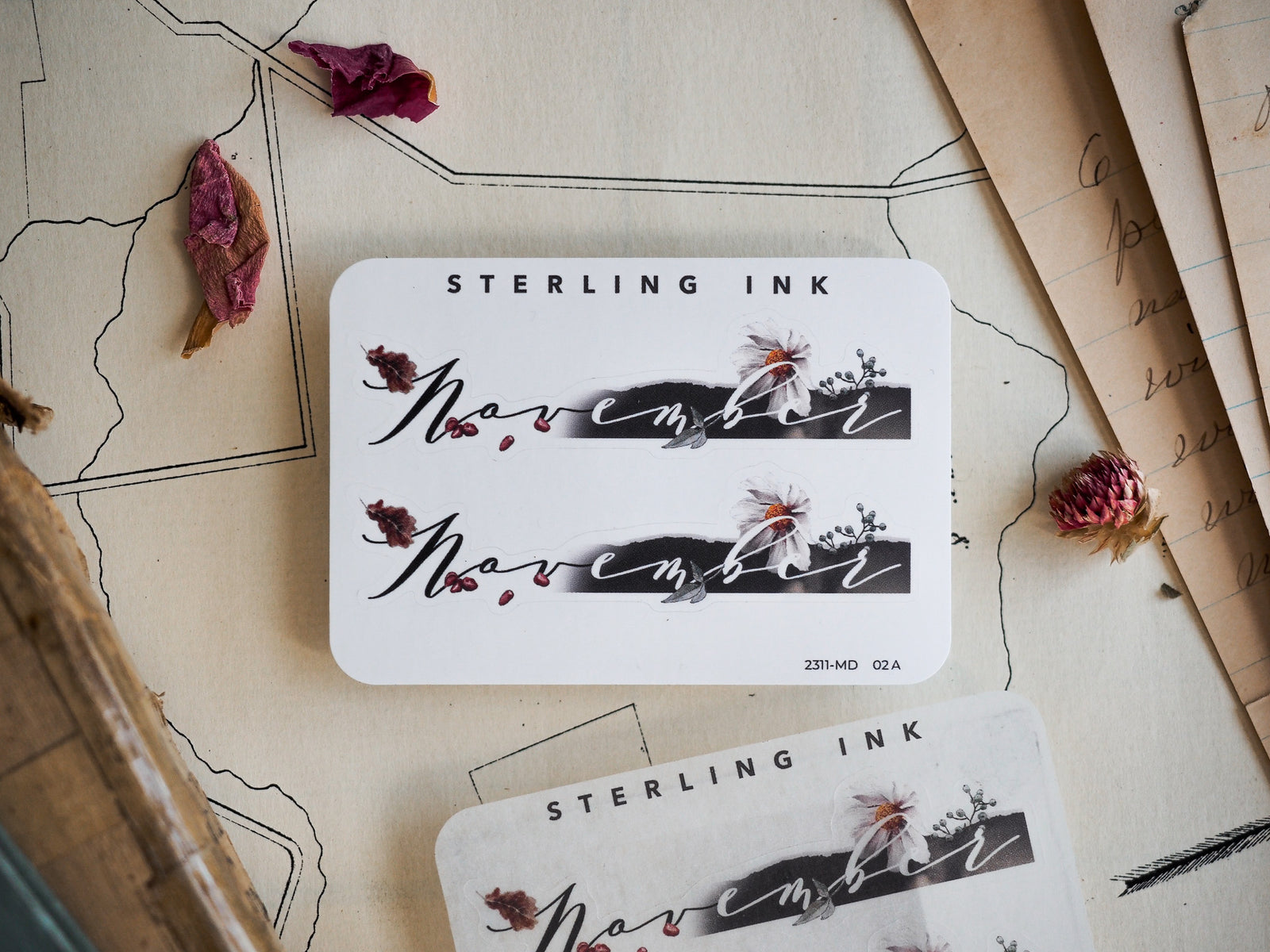 Elegant white "November" month sticker featuring graceful script lettering and delicate autumnal floral and leaf embellishments for planners.