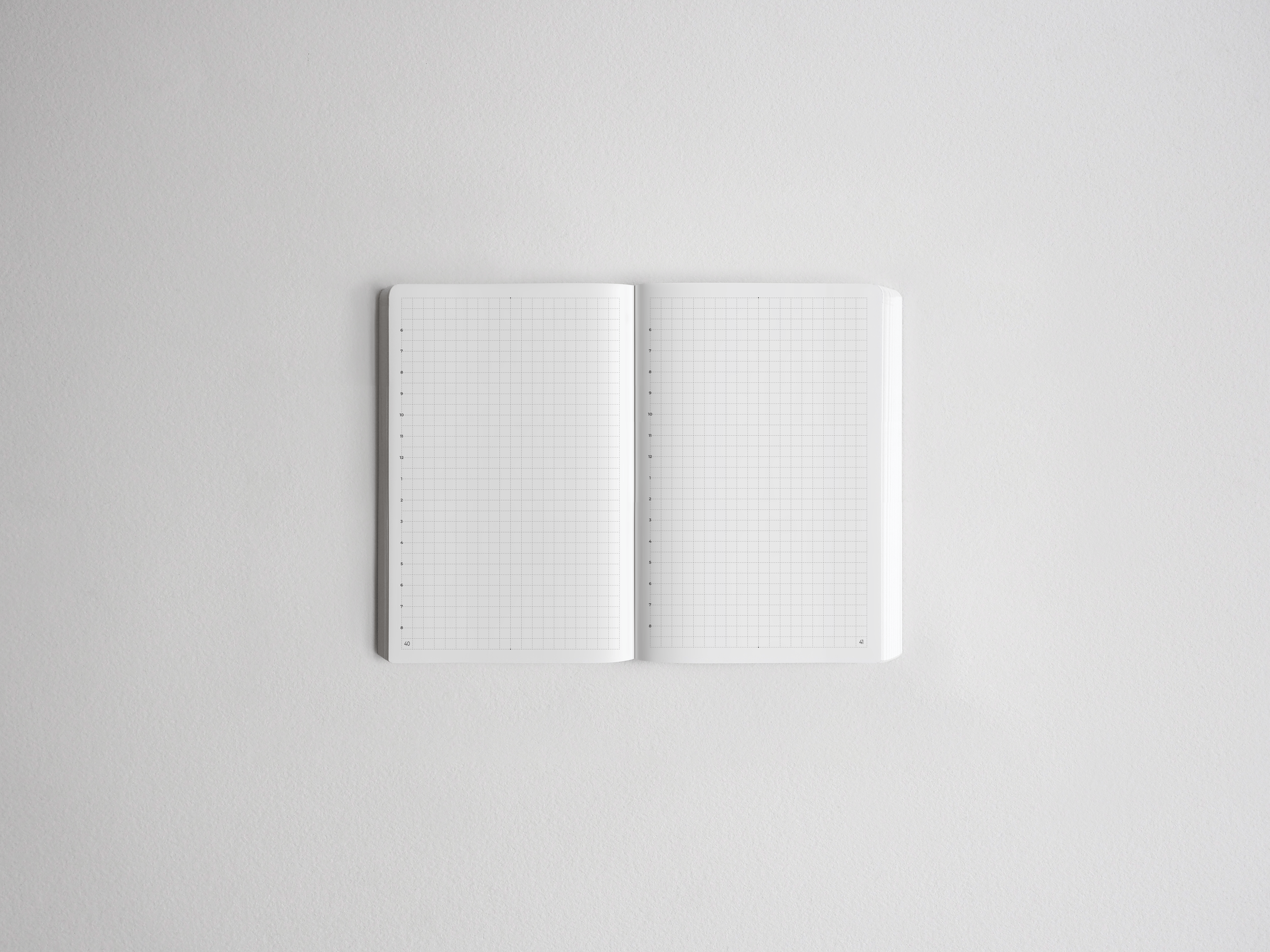 Open notebook featuring blank, white gridded pages, perfect for studying, planning, drawing, or bullet journaling.