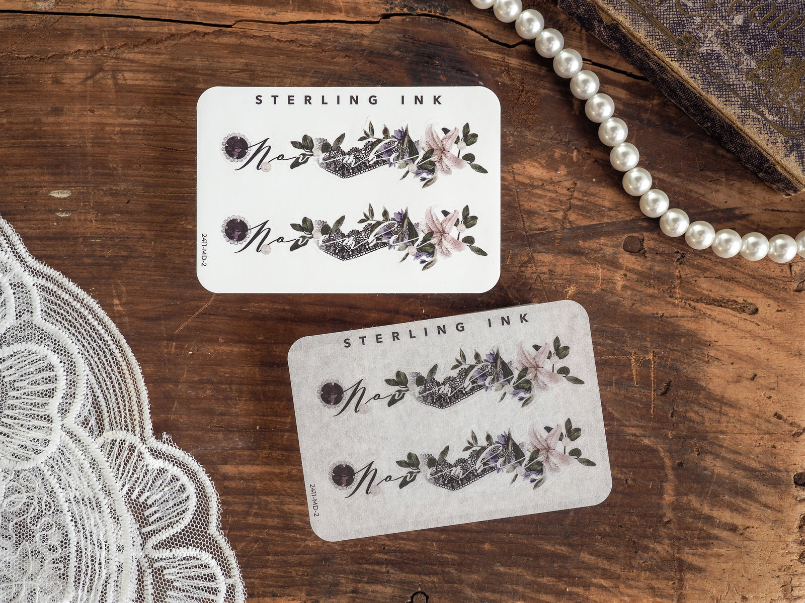 A set of two November month stickers featuring elegant journaling designs with watercolor floral clusters in shades of mauve, purple, and sage green.