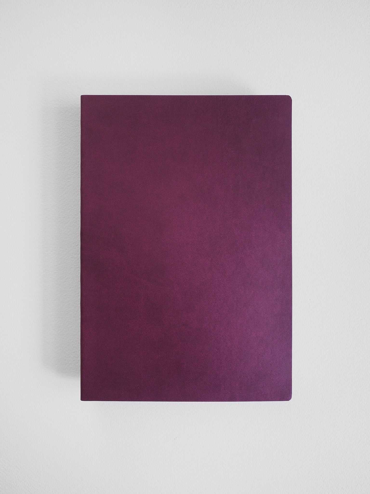 Solid, deep plum-colored A5 grid notebook cover, presenting a minimalist, matte design ready for writing.