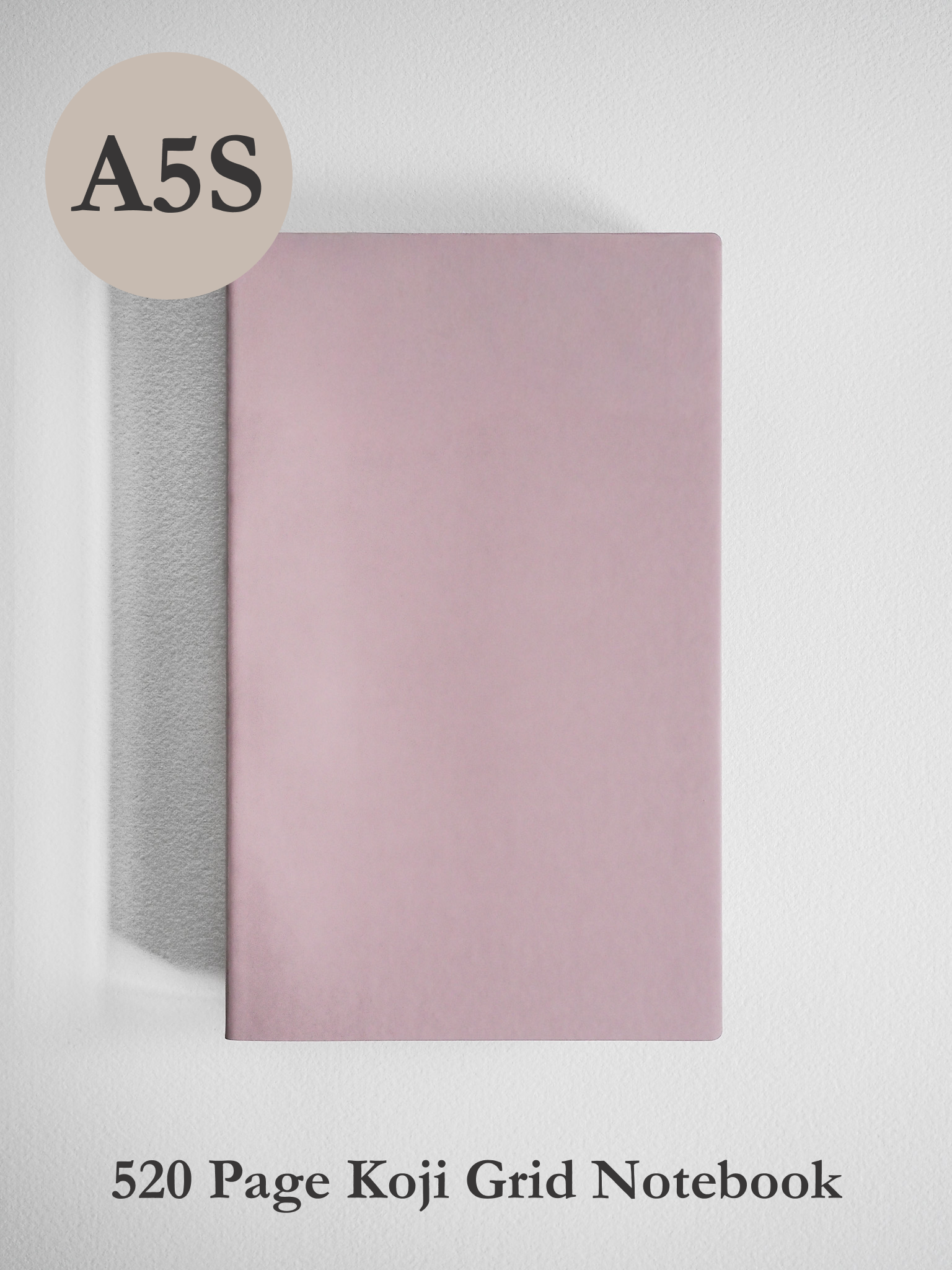 Stylish A5 slim notebook with a solid pale blush pink cover, featuring 520 pages of grid paper and premium Koji paper for writing.