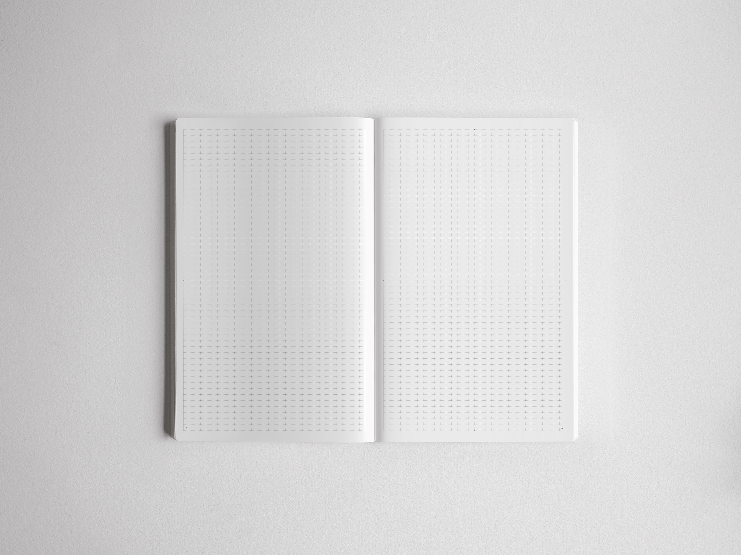 Open, minimalist A5 grid notebook showing light graph paper lines across crisp white pages, perfect for detailed planning, drafting, or note-taking.