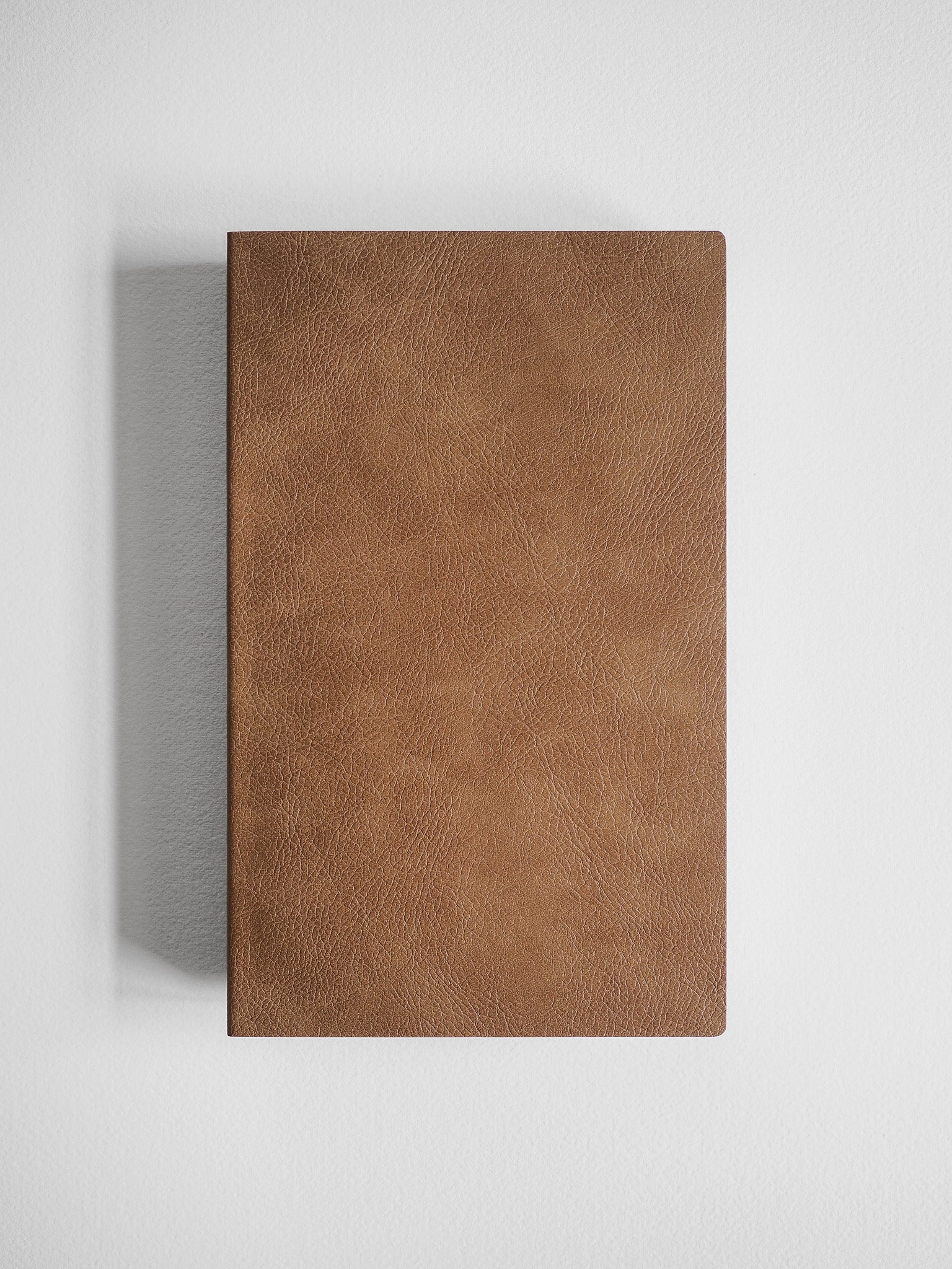Matte A5 notebook cover featuring a smooth, uniform, cognac-brown leather-textured finish.