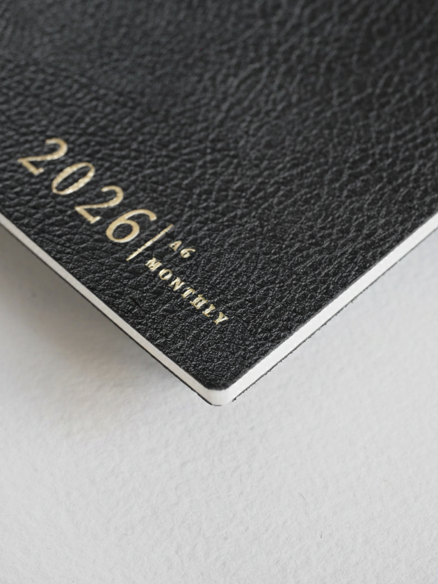 Elegant dark gray A6 monthly planner cover for 2026, featuring minimalist silver lettering that clearly displays "2026 | A6 | MONTHLY."