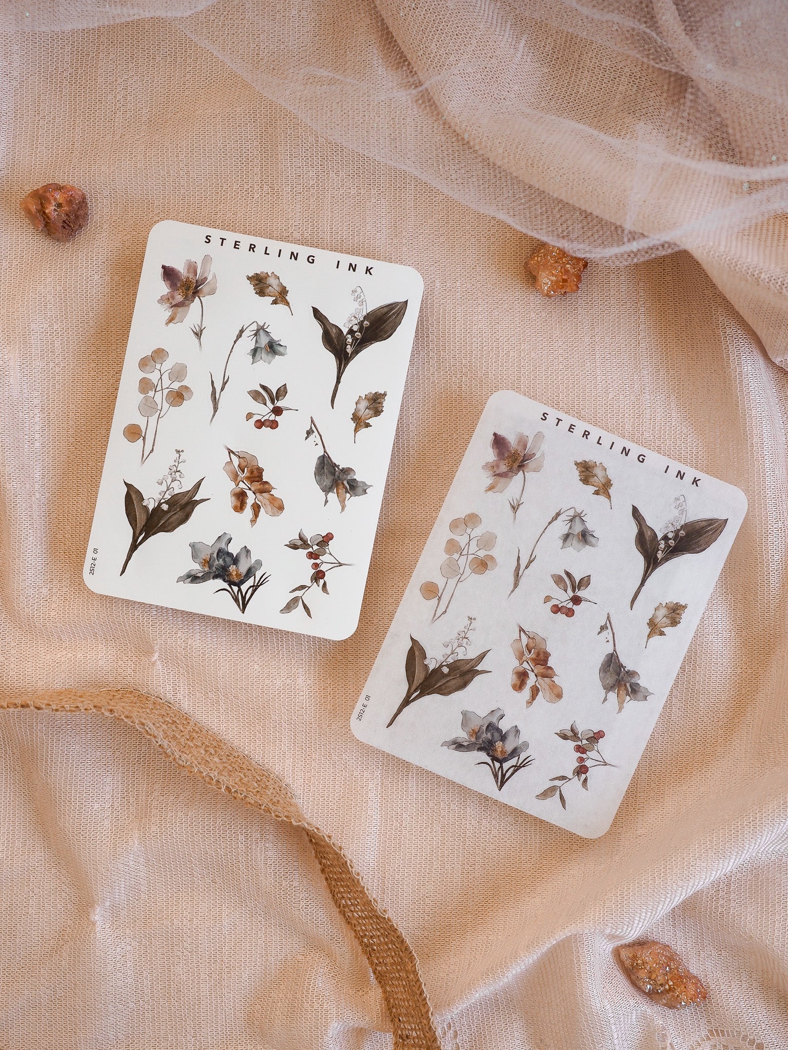 Sticker sheets featuring delicate, hand-illustrated botanical elements, showcasing dusty floral clusters and varied foliage in muted, earthy autumnal tones.