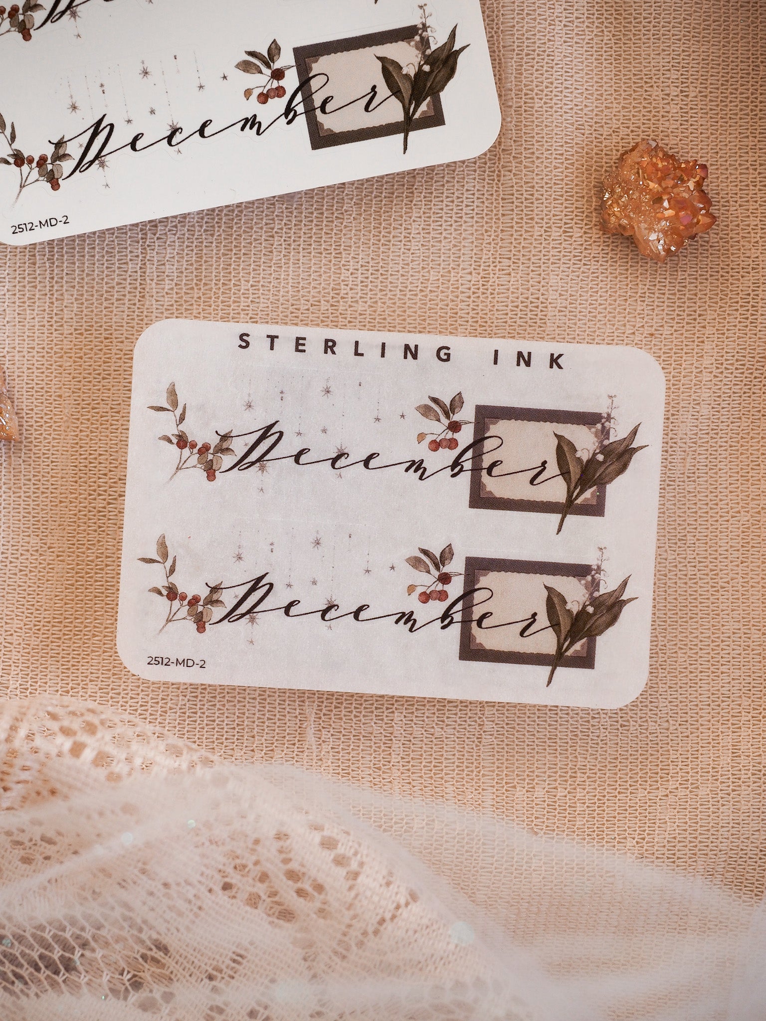 Elegant December month sticker set featuring a scripted font framed by rustic borders and accented with muted watercolor berries and dark leaves.