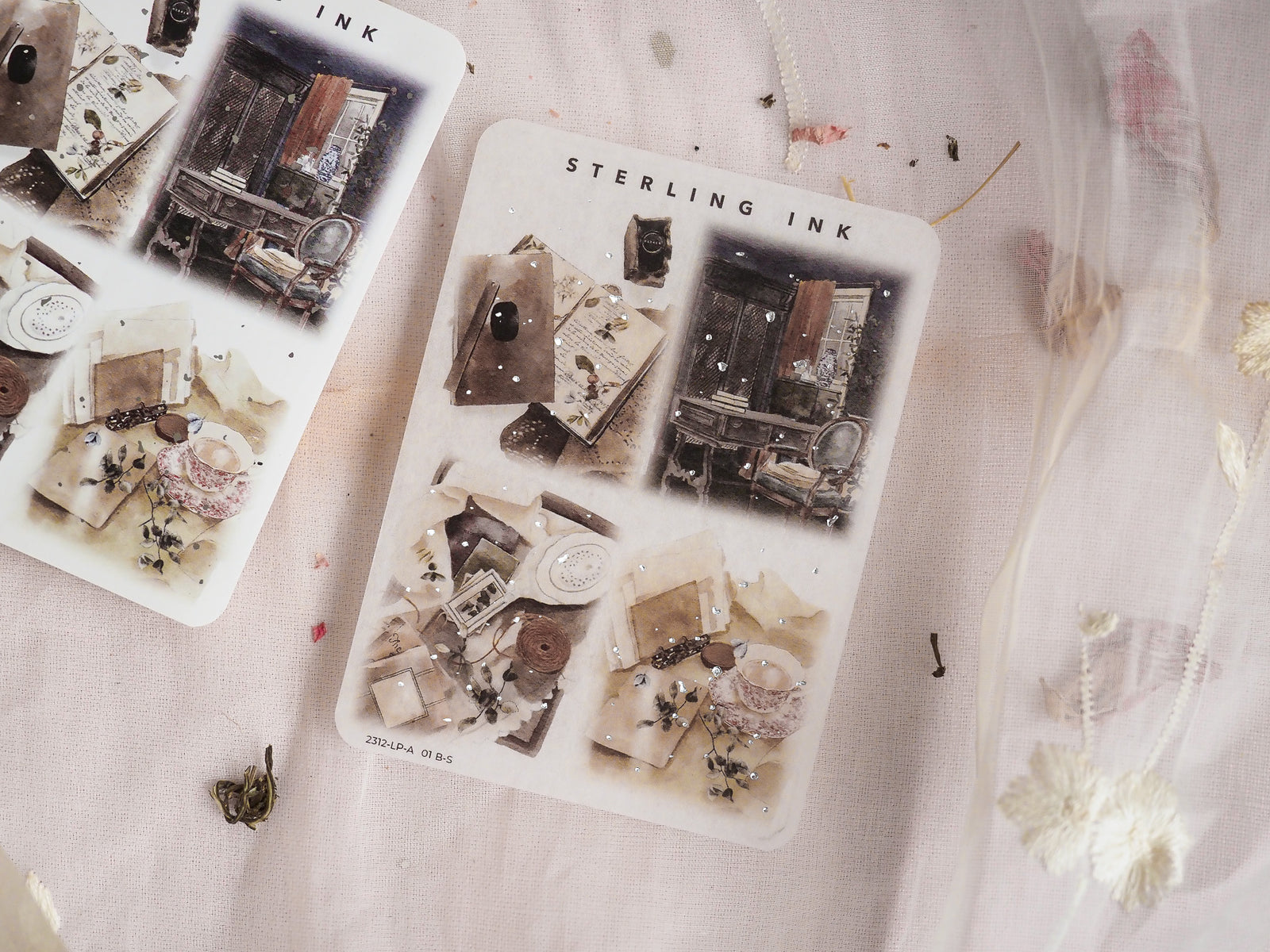 Vintage sticker sheet featuring sepia-toned illustrations of antique writing tools, old books, and scientific objects accented with delicate silver foil details.