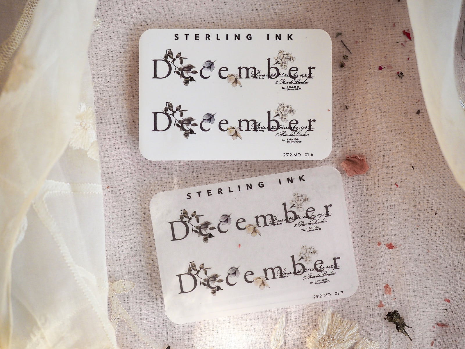 Set of white calendar stickers celebrating December, featuring black cursive script and delicate pressed floral accents perfect for journaling and planners.