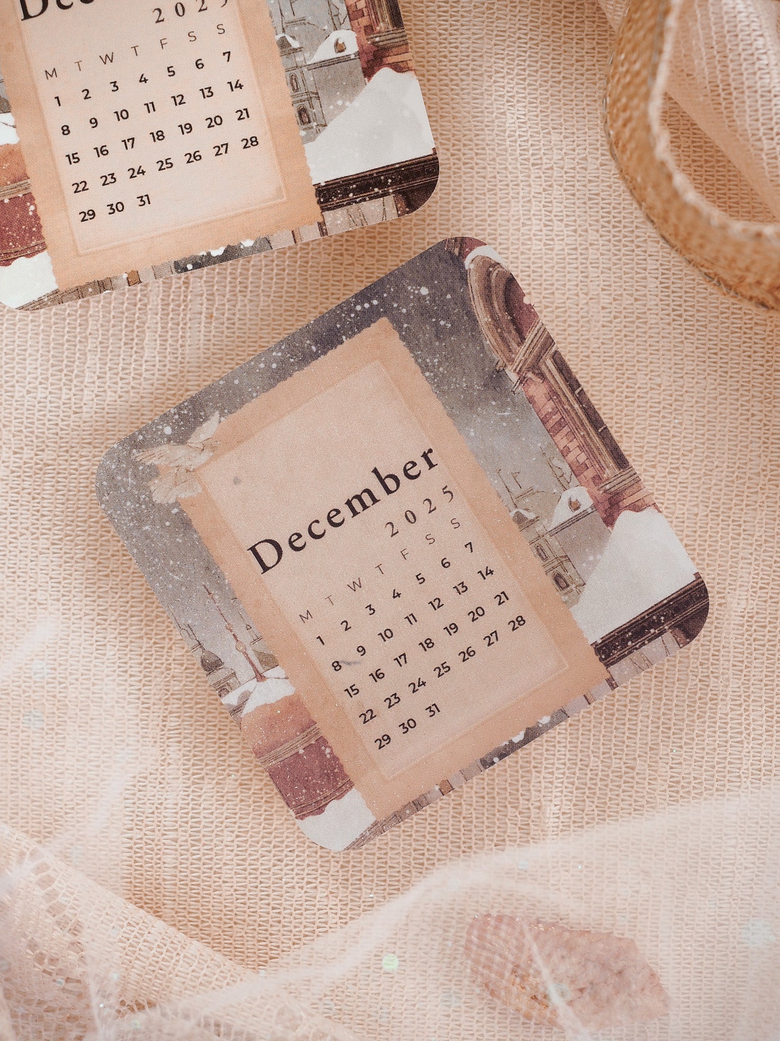 Vintage December 2025 monthly calendar displaying the dates in sepia tones over a distressed, snowy architectural scene.