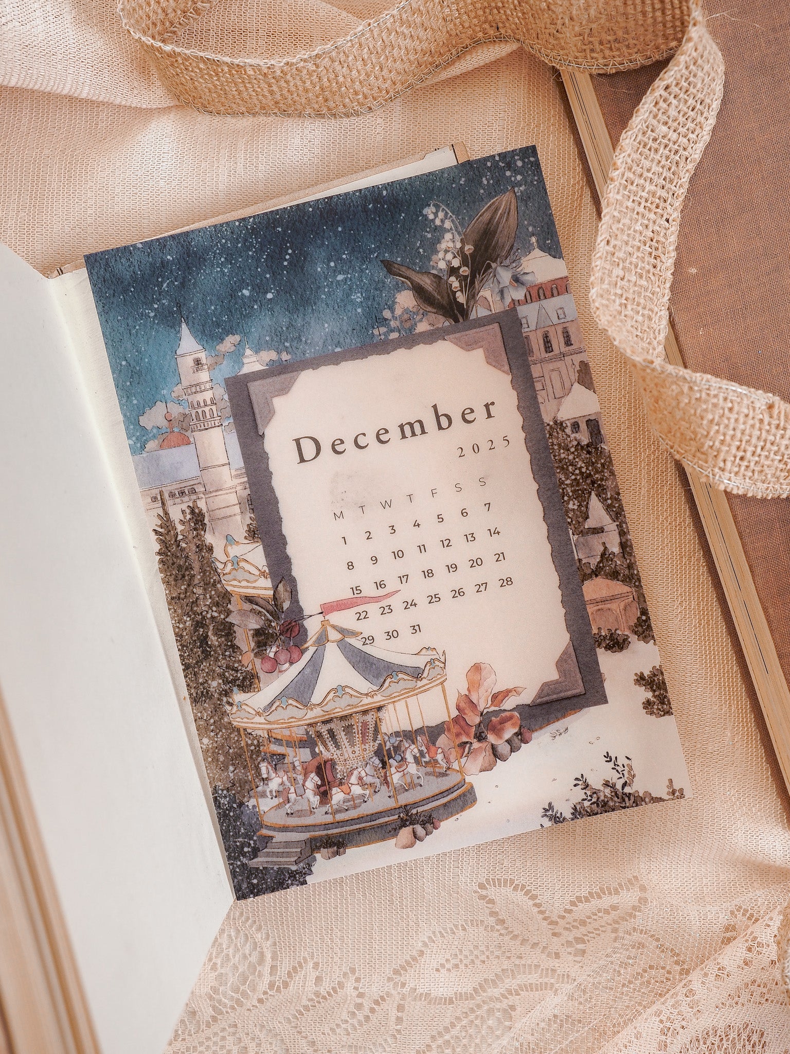 December 2025 calendar page featuring a charming, whimsical illustration of a carousel and European streetscape in muted autumnal tones.