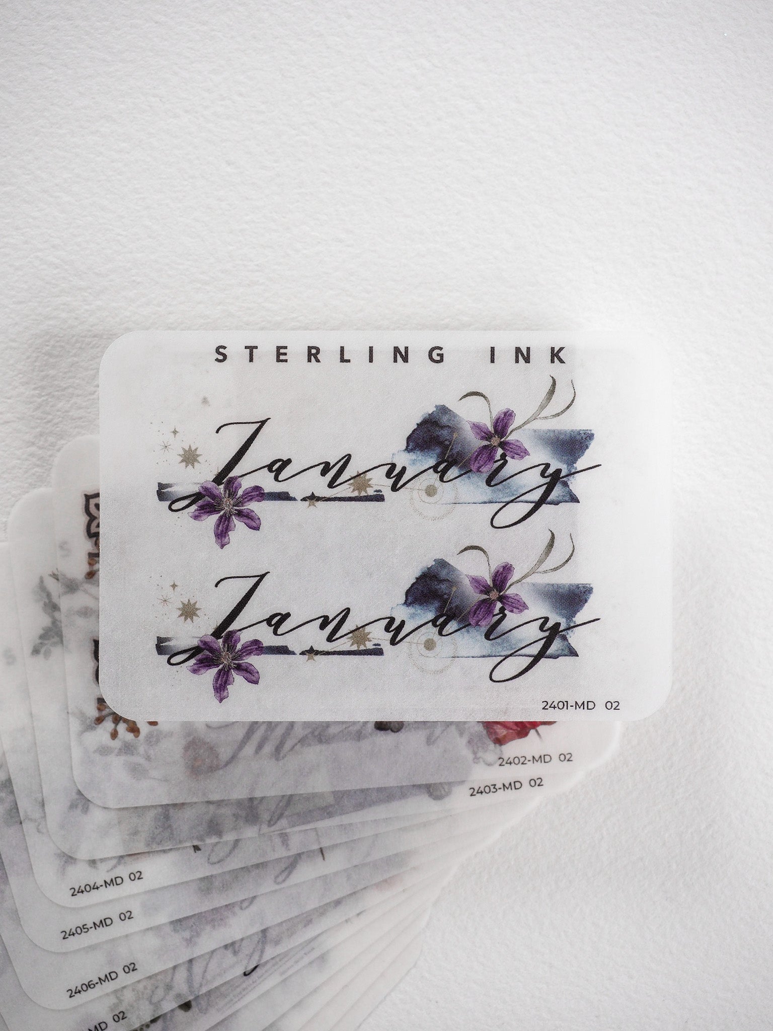 Elegant monthly sticker set featuring watercolor lavender and blue floral designs paired with sophisticated script lettering and gold accents for planners and journals.