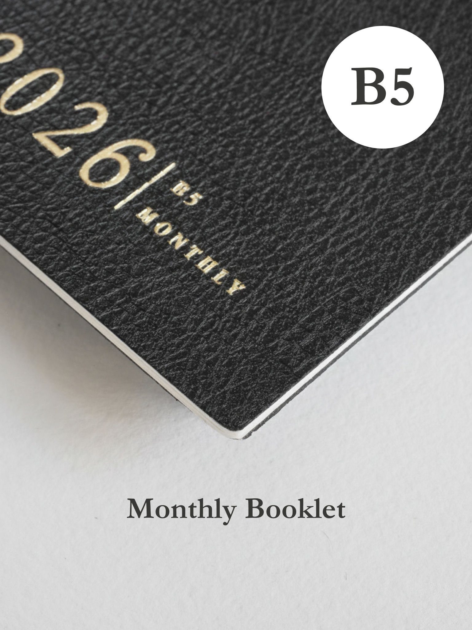 Minimalist dark charcoal B5 monthly planner booklet cover featuring the year 2026 and contemporary, elegant block typography.