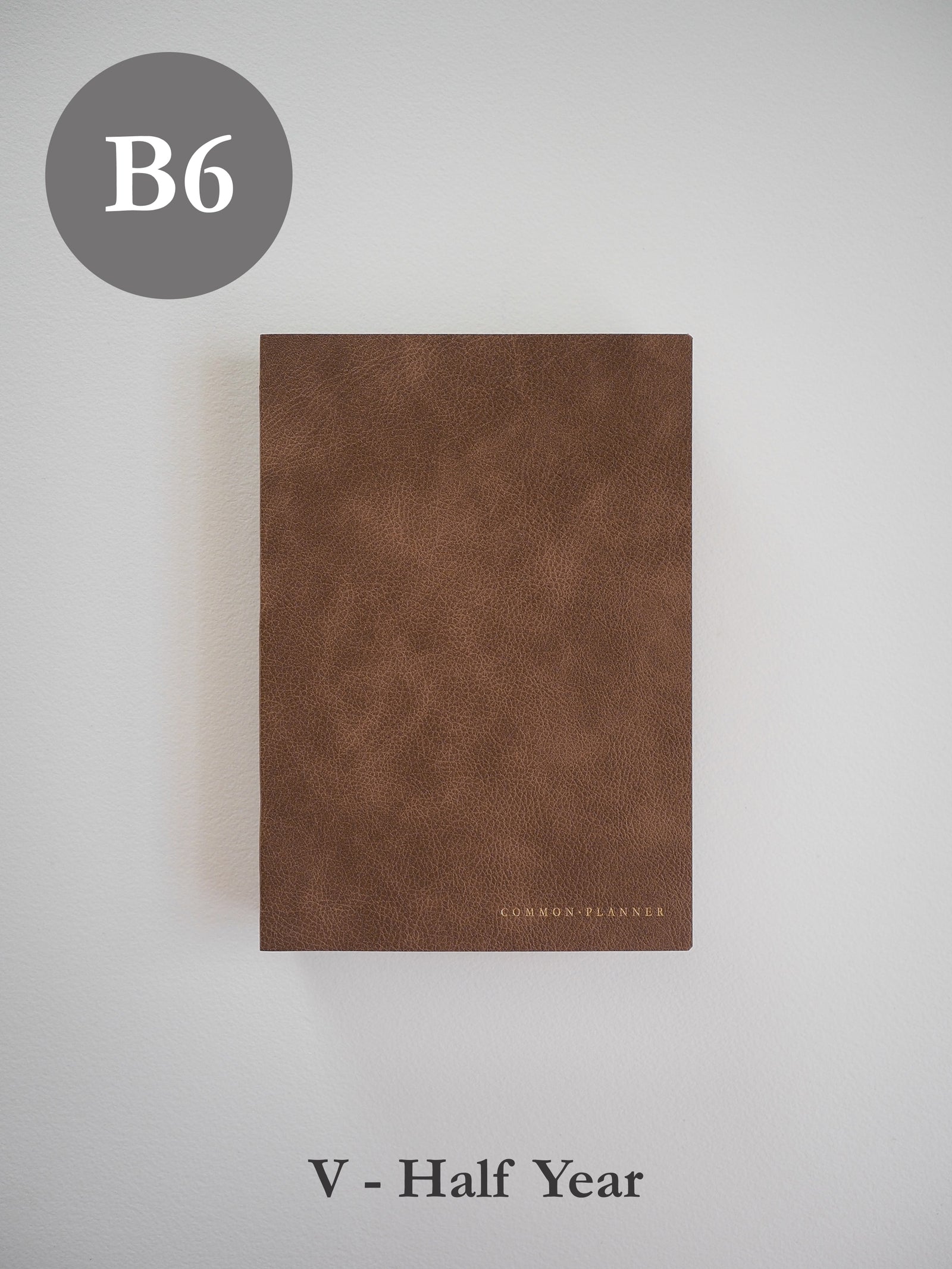 Minimalist B6 vertical planner featuring a rich, matte brown, textured cover stamped subtly with the "COMMON PLANNER" branding.