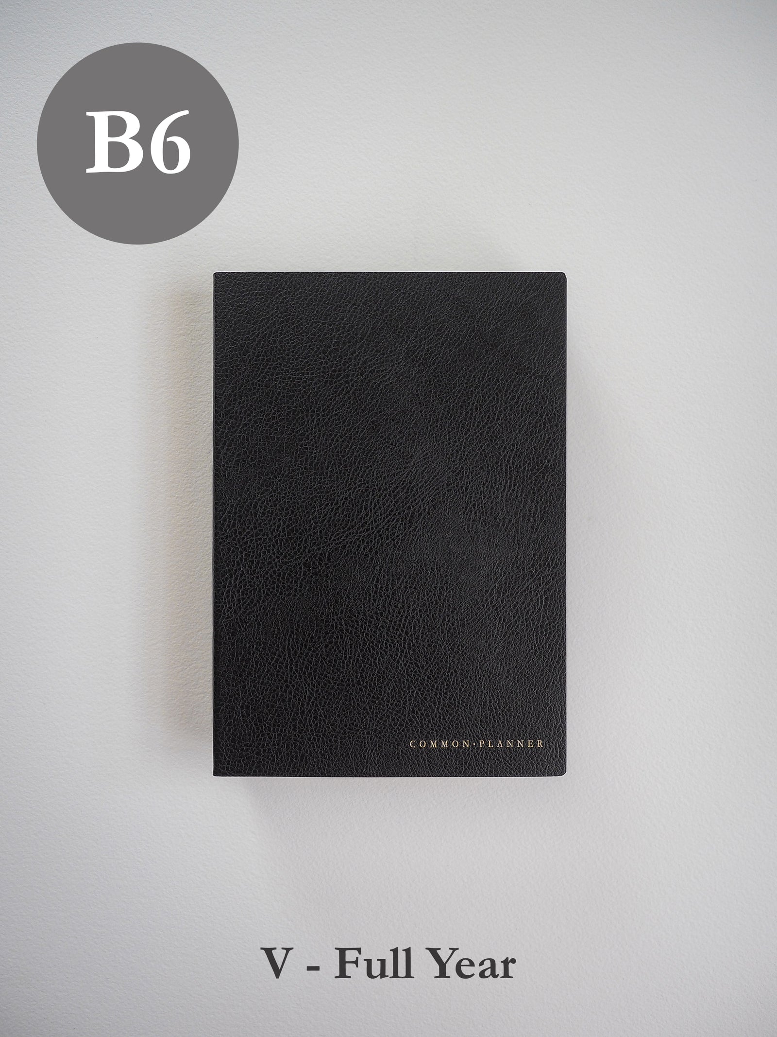 Minimalist black B6 vertical planner with a textured faux leather cover and discreet "Common Planner" branding, suitable for full-year undated use.