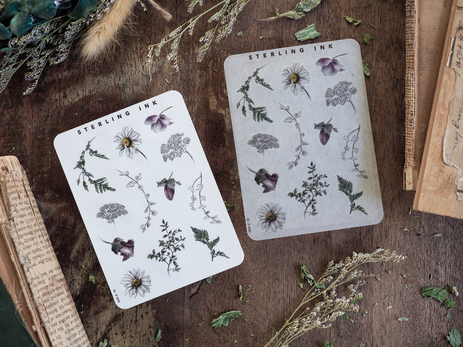 Detailed botanical sticker sheets featuring black and gray ink illustrations of delicate flowers, leaves, and herbs, perfect for journal decorating.