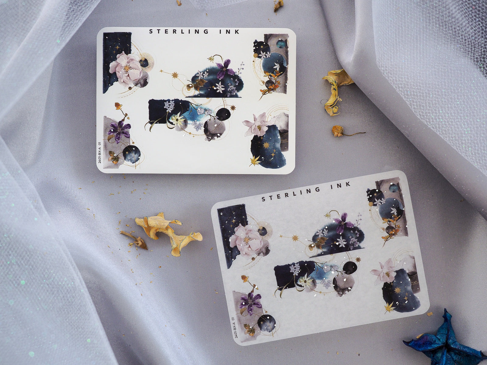 Watercolor and celestial stickers featuring rich navy blues, delicate florals, and glittering silver foil accents, perfect for journaling or planning.