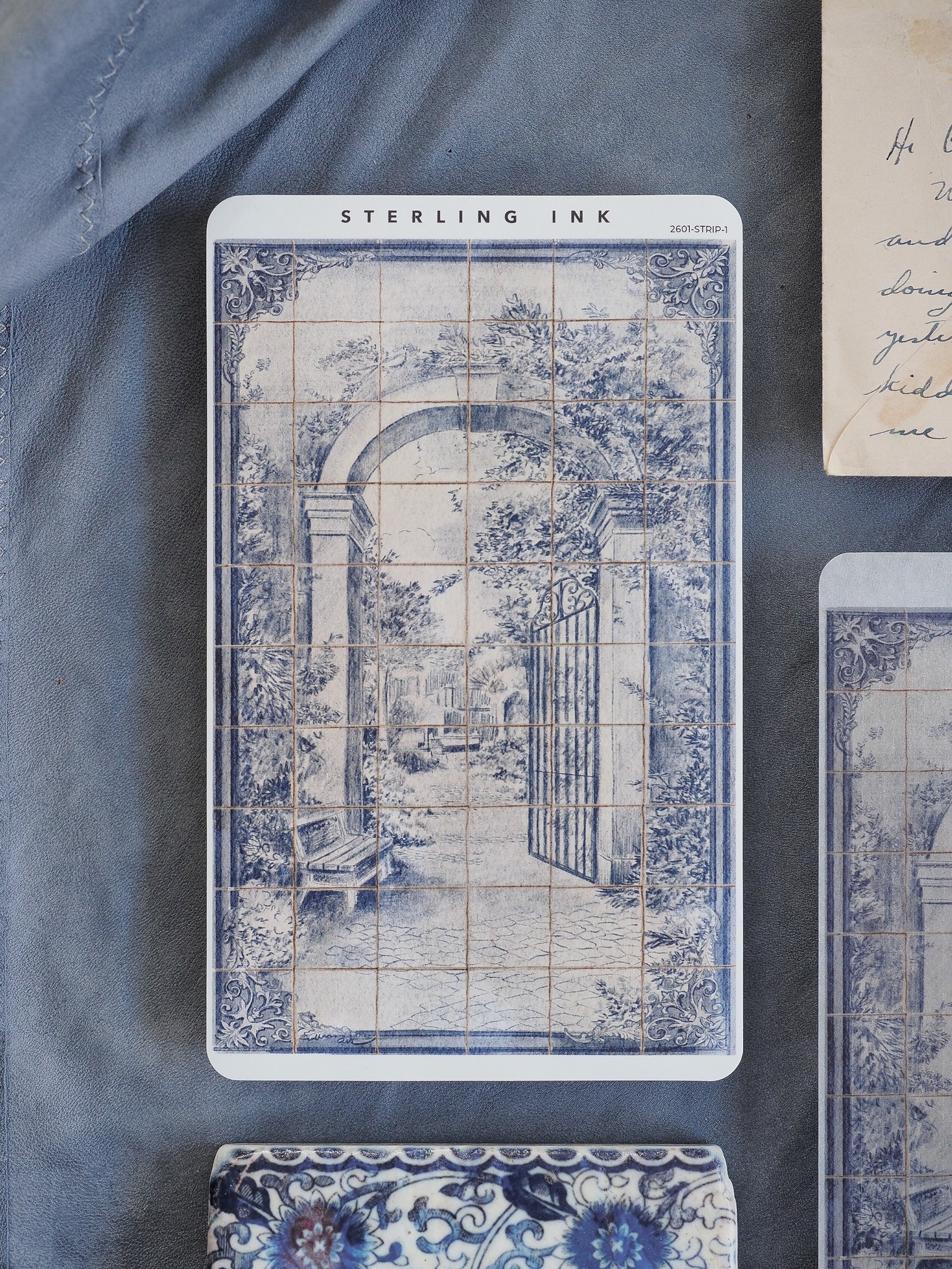 Antique blue and white printable strip stickers featuring a detailed European street scene with arches and tiled architectural patterns.