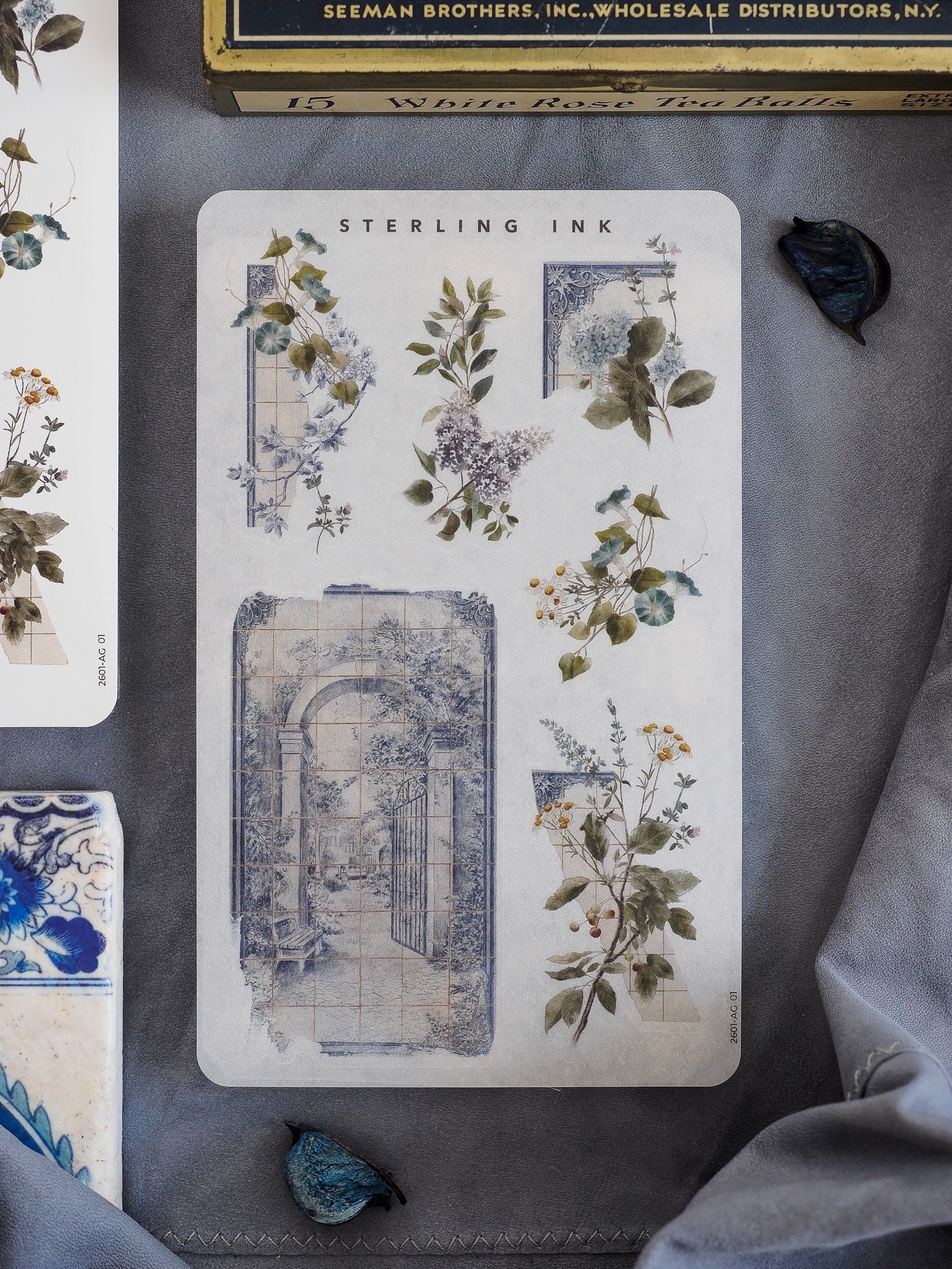 Elegant sticker sheet featuring muted botanical clusters and a large, faded blue architectural arch, evoking a vintage, historic journal aesthetic.