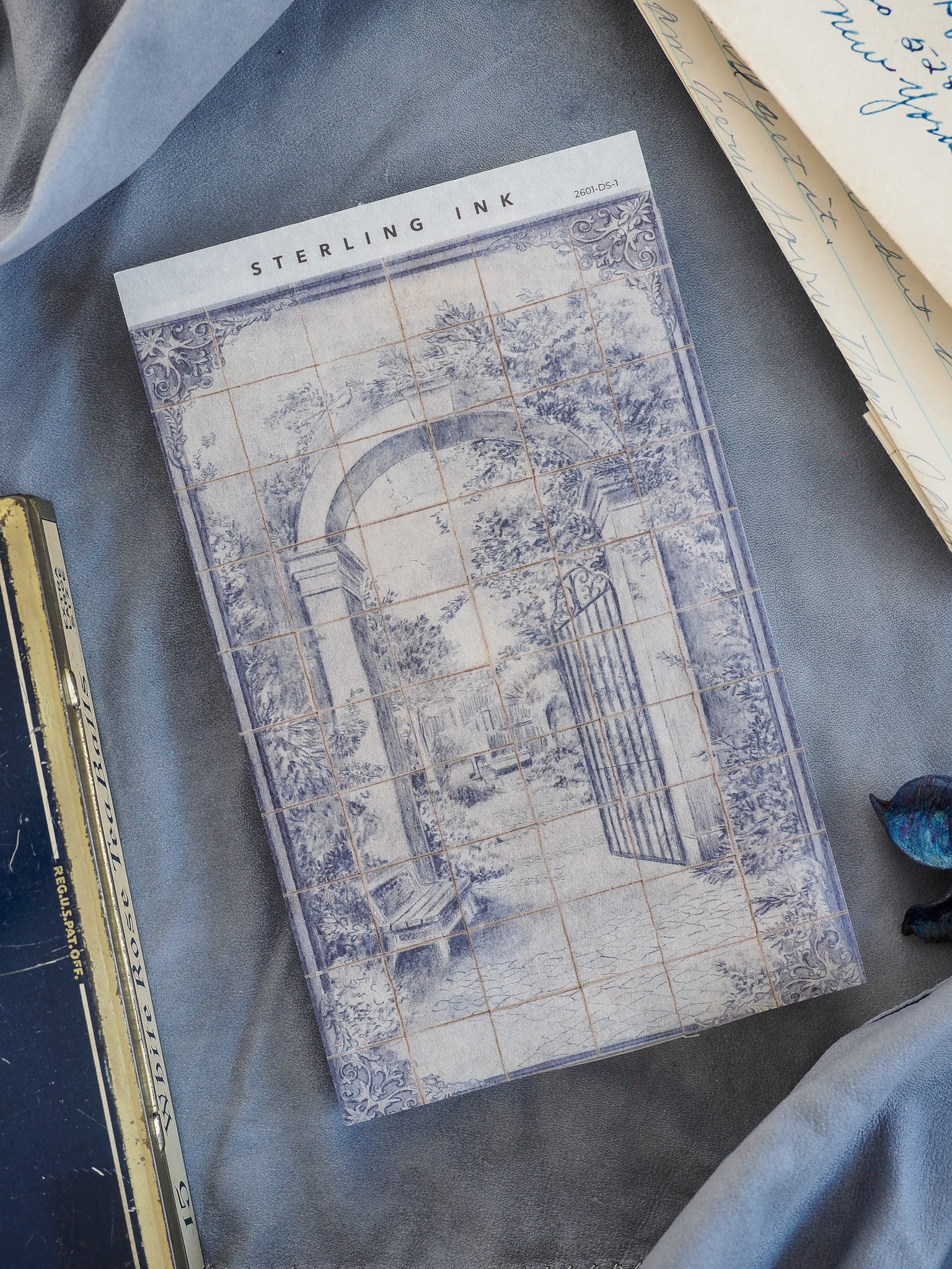 Vintage blue-gray Deco Sheet for January 2026, featuring a faded, detailed architectural archway framed by a decorative, grid-patterned design.