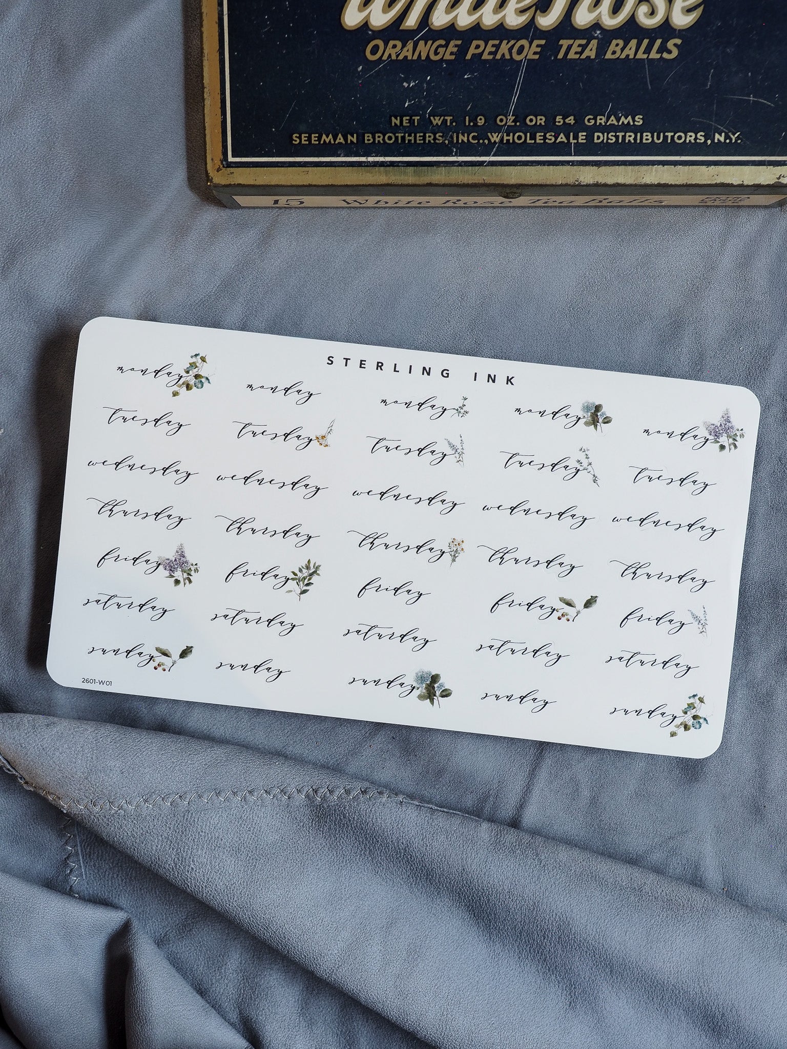 Vintage-style sticker sheet labeling weekdays, decorated with small, detailed black ink floral clusters, perfect for journaling and calendar planning.